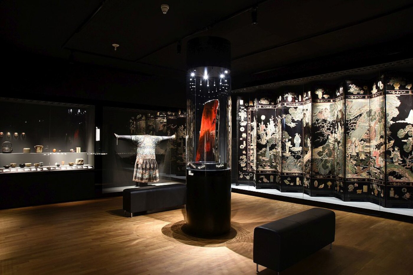 Ein ausgeleuchteter Museumsraum mit mehreren asiatischen Exponaten