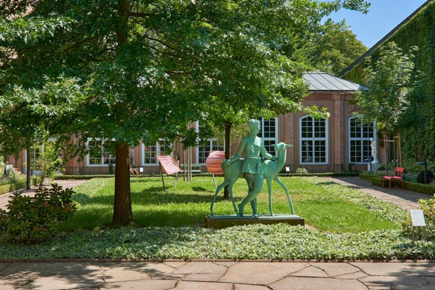 Eine kleine Parkfläche mit Bänken vor einem Gebäude mit großen Fenstern