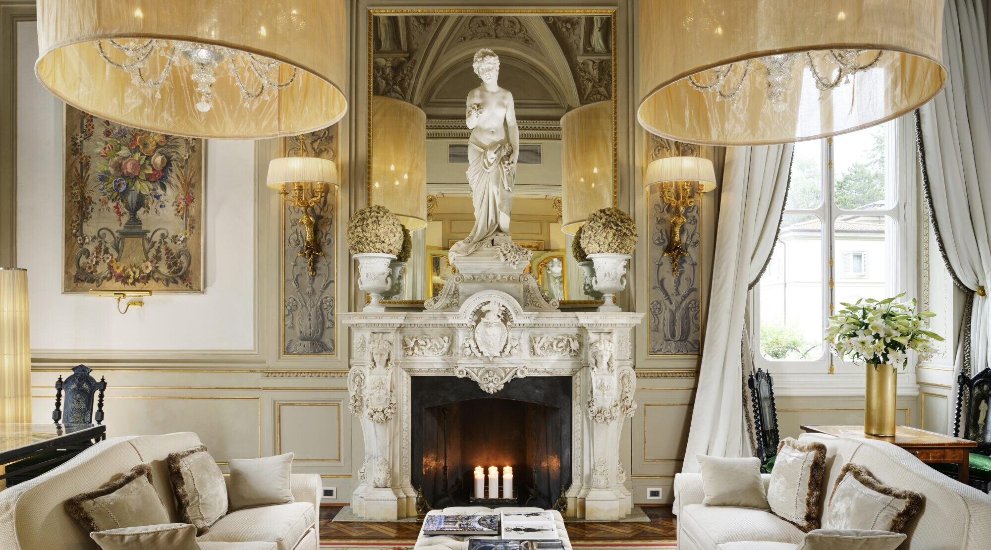 Luxuriöses Hotelzimmer mit cremefarbenen Sofas und Kamin