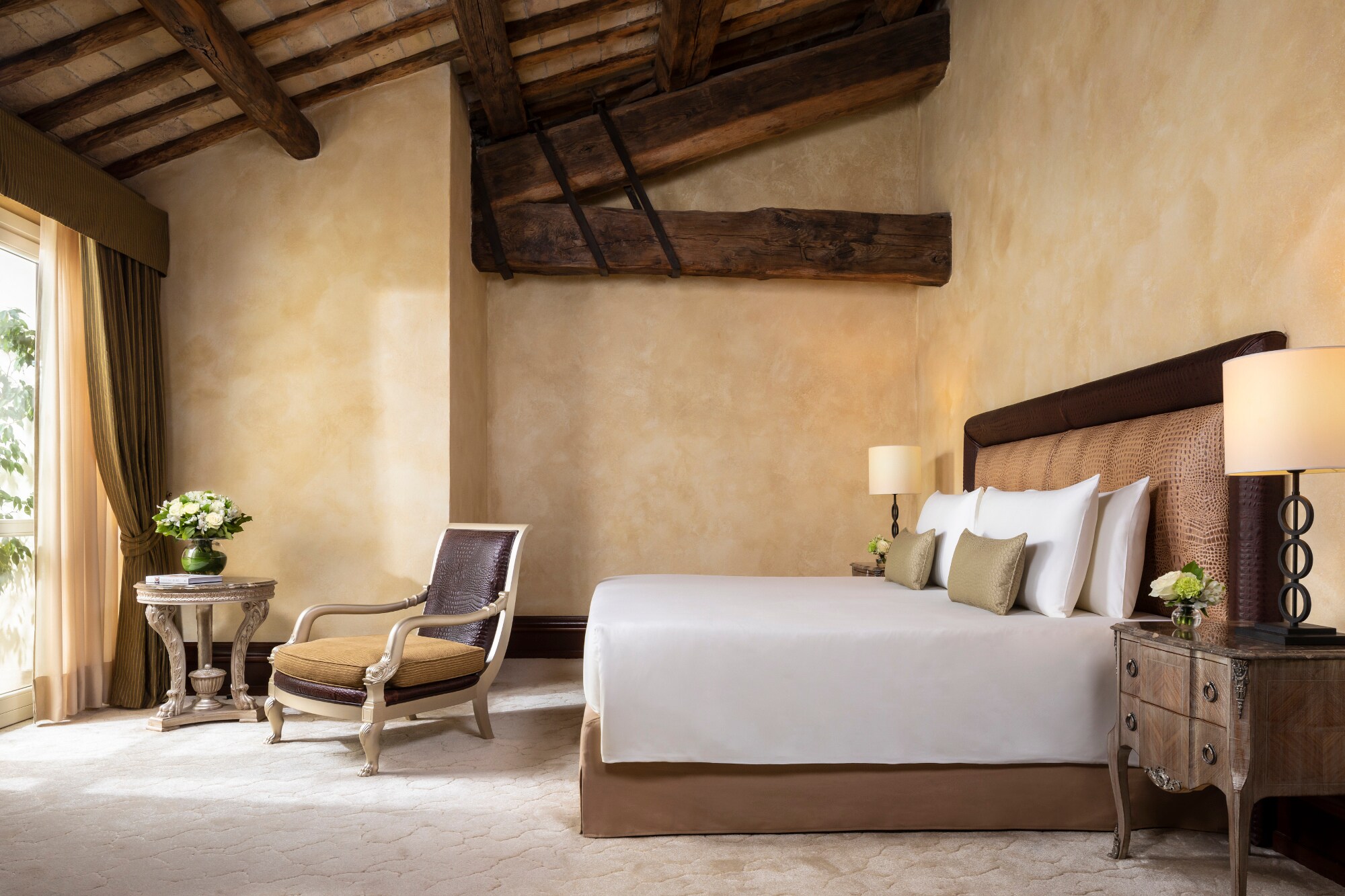 Innenausstattung eines stilvoll eingerichteten Hotelzimmers mit Doppelbett und massiven Deckenbalken aus Holz Innenausstattung eines stilvoll eingerichteten Hotelzimmers mit Doppelbett und massiven Deckenbalken aus Holz