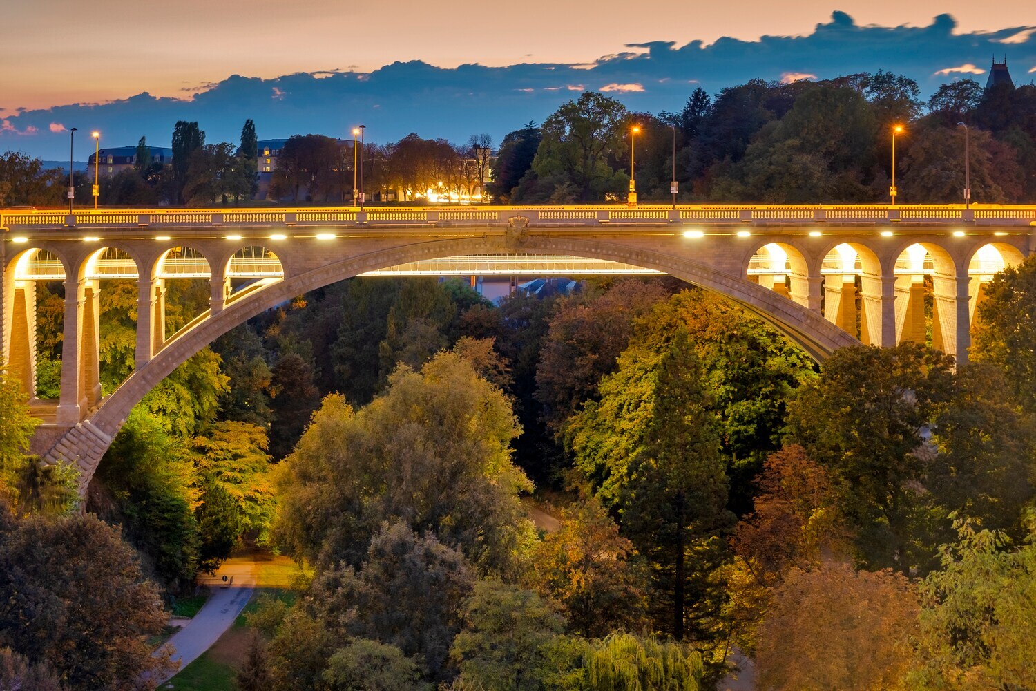 Blick auf die beleuchtete Adolphe-Brücke in Luxemburg in der Dämmerung.