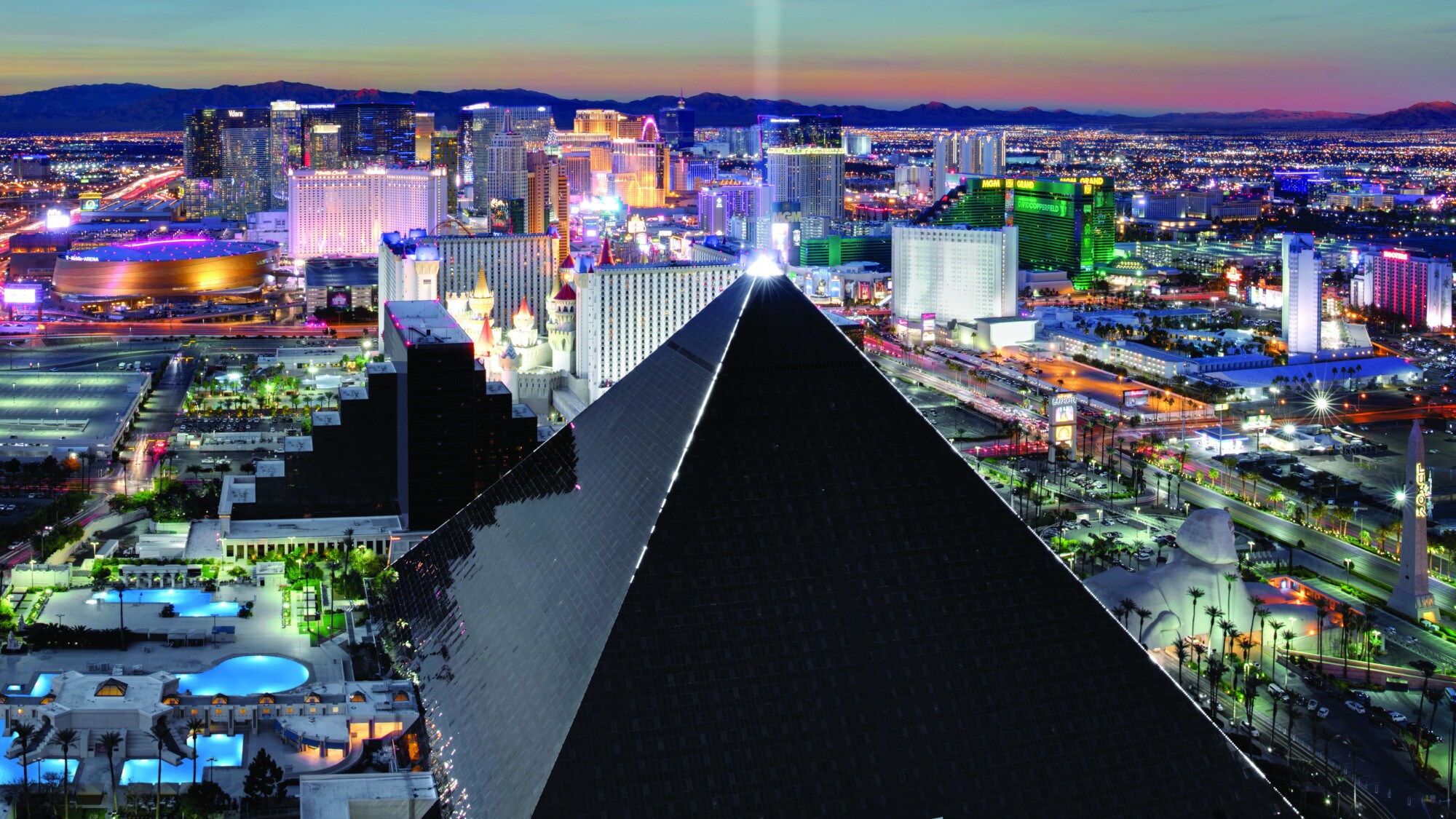 Luftaufnahme von Las Vegas bei Nacht mit einem schwarzen, pyramidenförmigen Gebäude Luftaufnahme von Las Vegas bei Nacht mit einem schwarzen, pyramidenförmigen Gebäude
