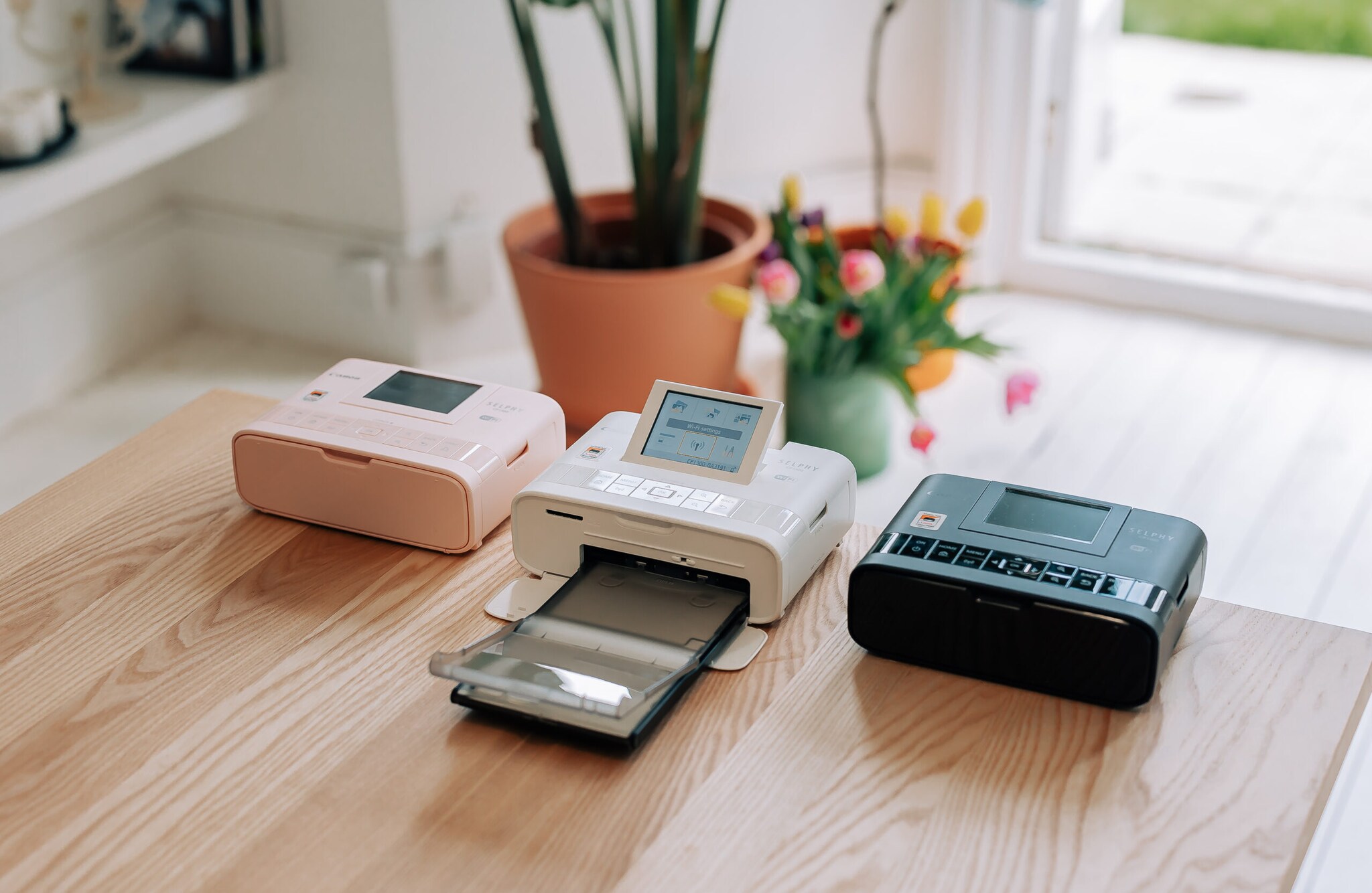 Drei Mini-Fotodrucker auf einem Holztisch