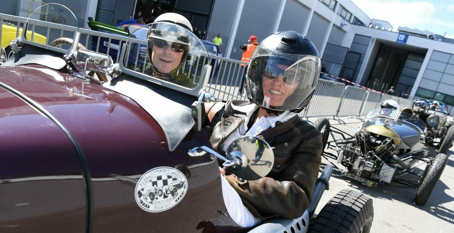 Zwei Menschen mit Helmen in einem Oldtimer