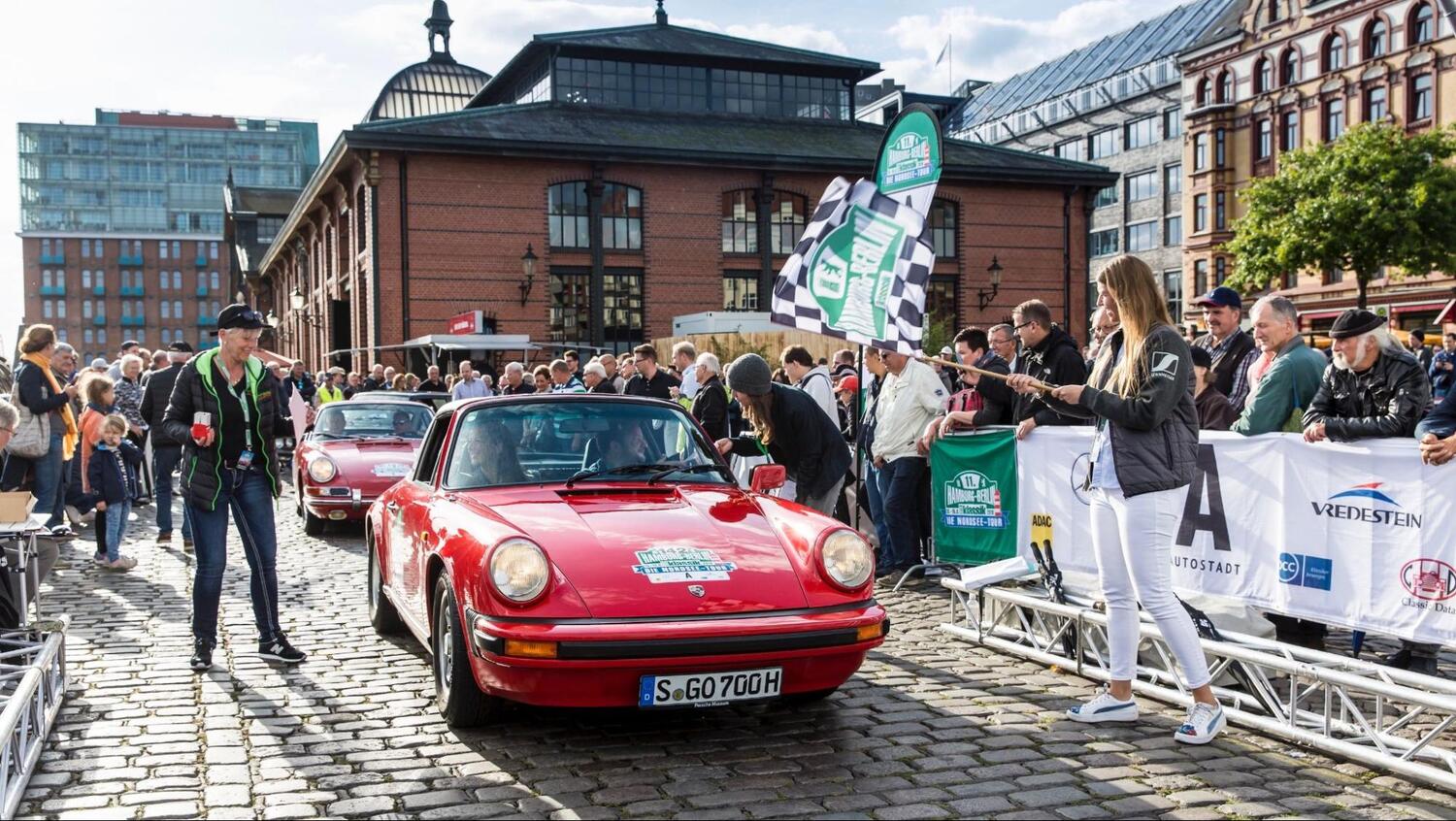 Ein roter Porsche am Start einer Rallye