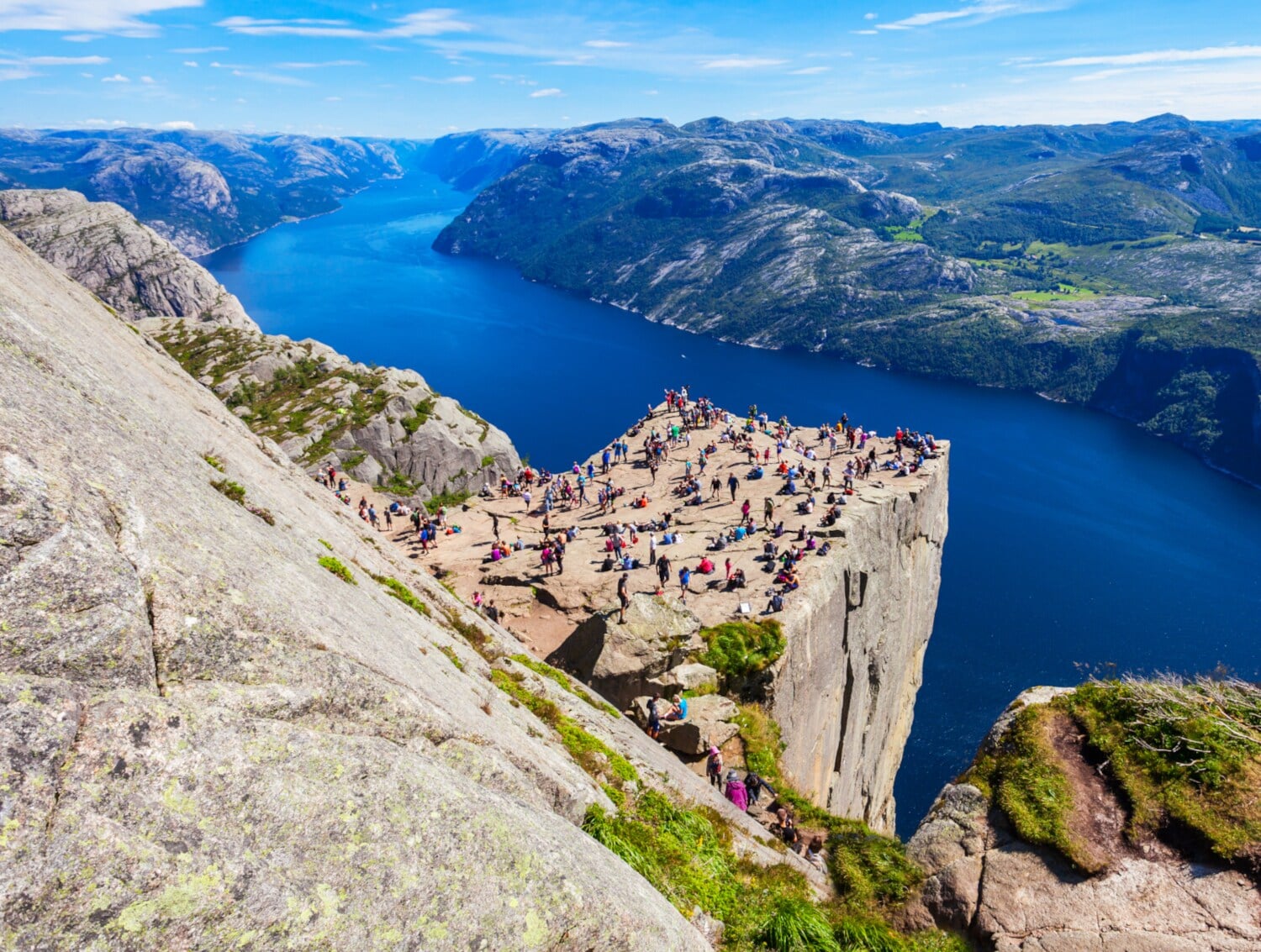 Ein Felsvorsprung mit vielen Menschen an einem Fjord Ein Felsvorsprung mit vielen Menschen an einem Fjord