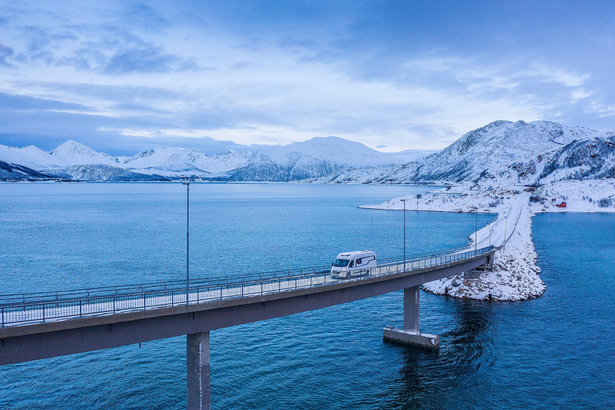 Luftaufnahme einer Brücke an einer Küste mit einem Wohnmobil Luftaufnahme einer Brücke an einer Küste mit einem Wohnmobil
