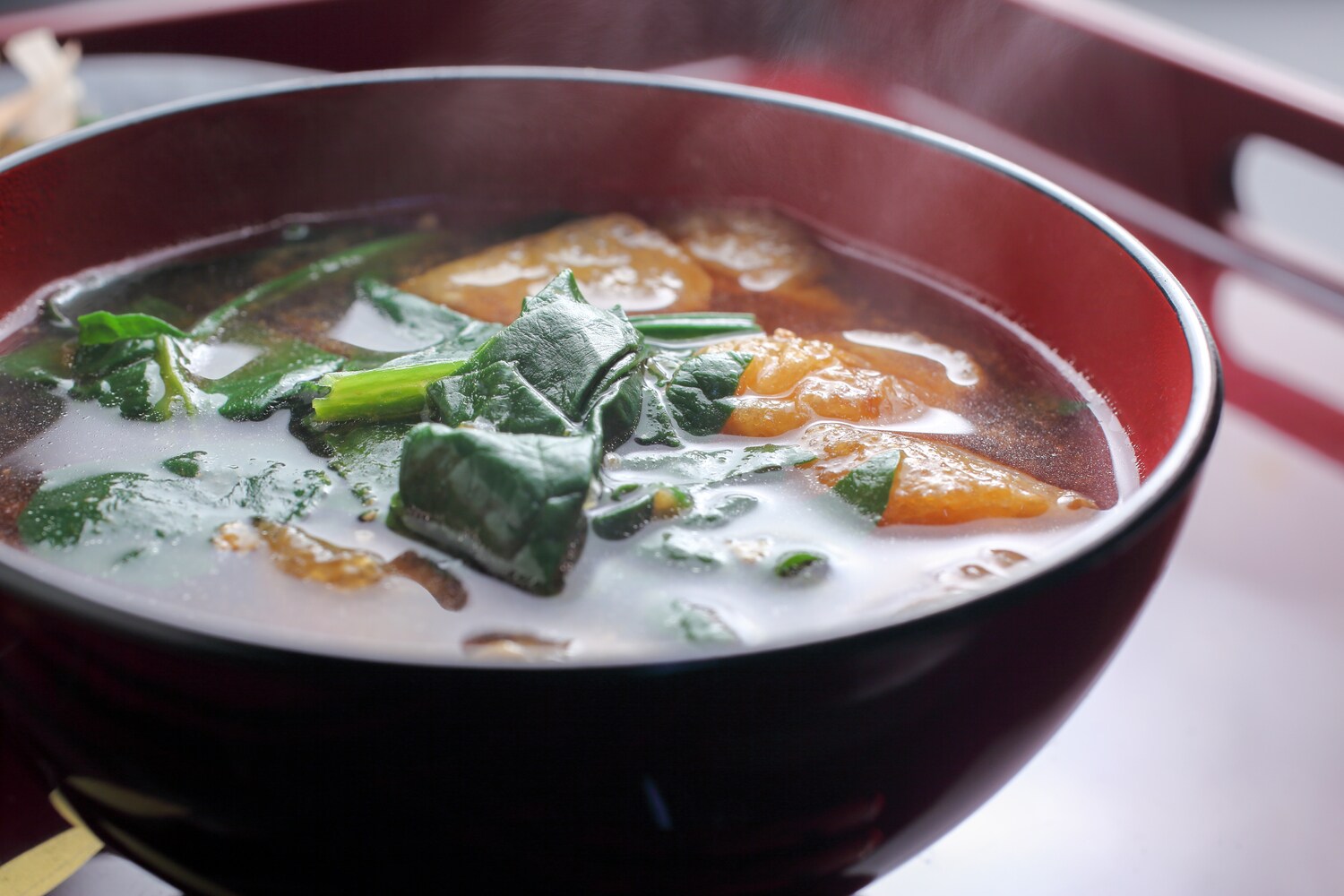 Eine Schüssel mit Misosuppe und Spinat. Eine Schüssel mit Misosuppe und Spinat.