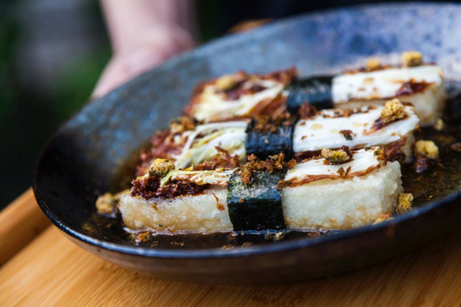 Ein asiatisches Gericht auf einem dunklen Teller. Ein asiatisches Gericht auf einem dunklen Teller.