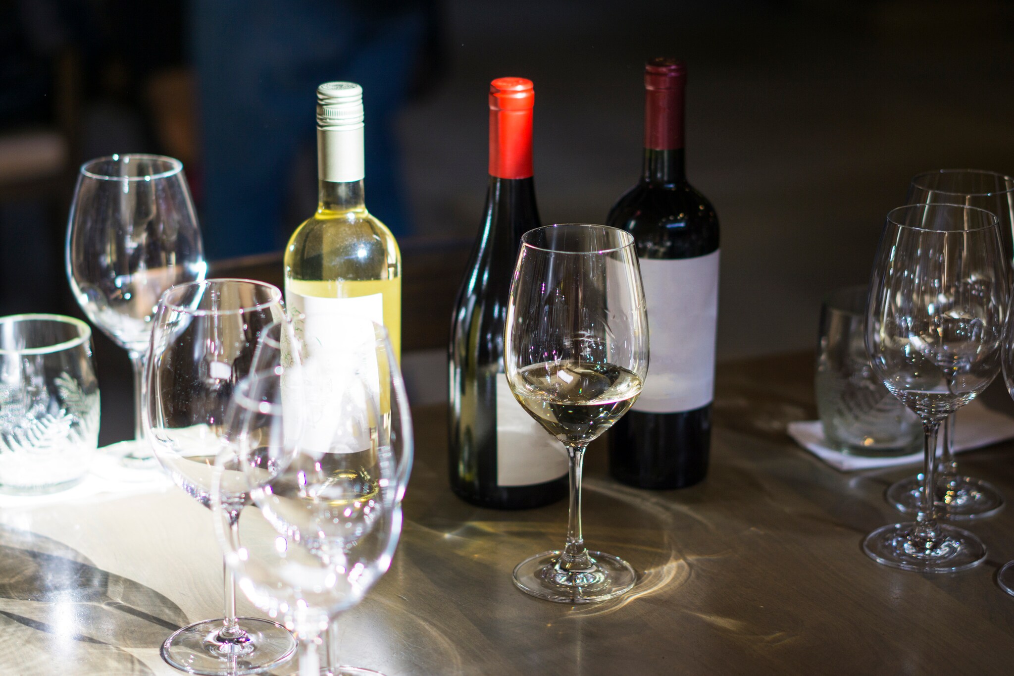 Mehrere Weingläser und Weinflaschen auf einem Tisch