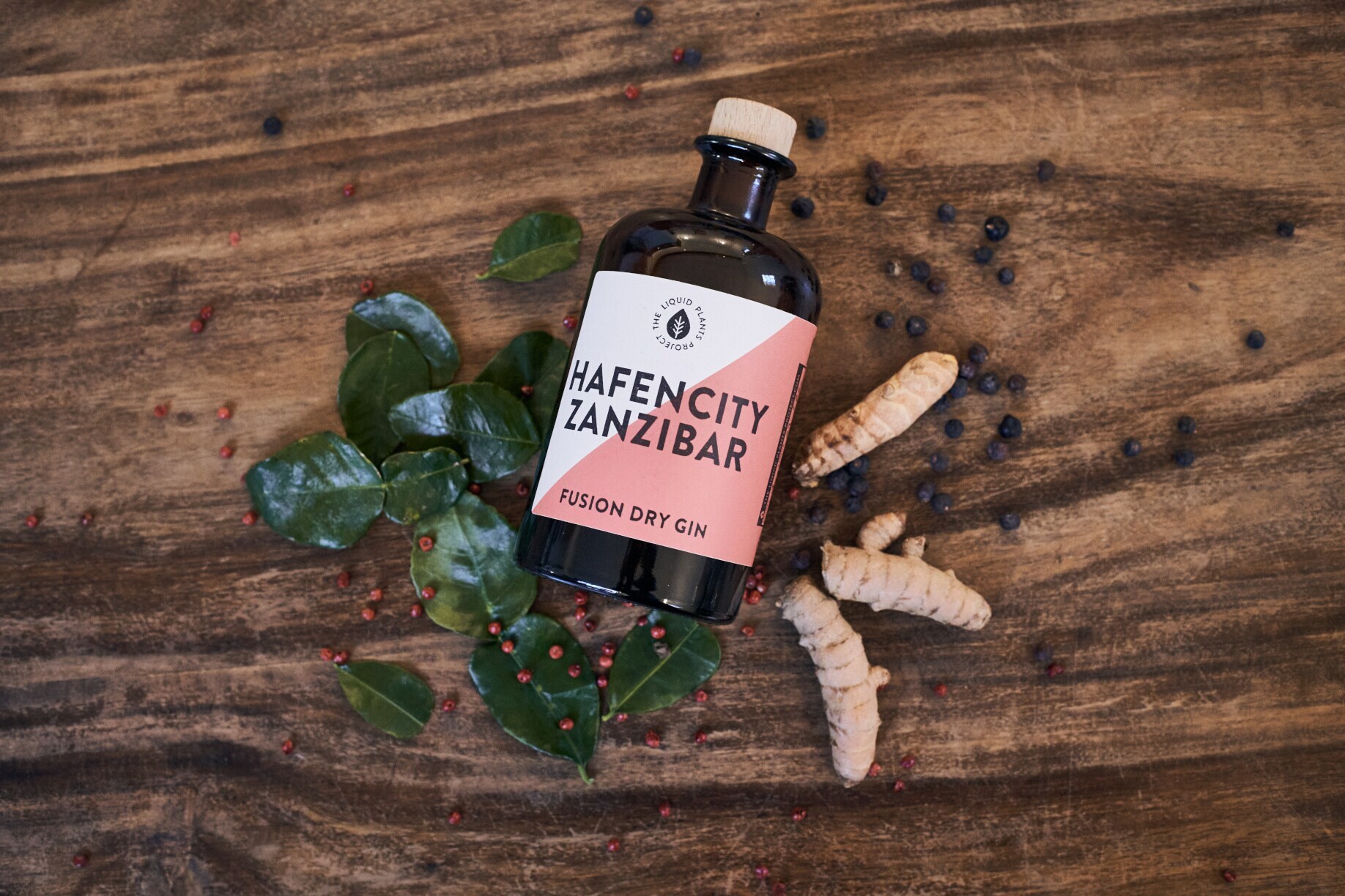 Flasche Hafencity Zanzibar auf einem Tisch mit Blättern, Kurkuma und Beeren