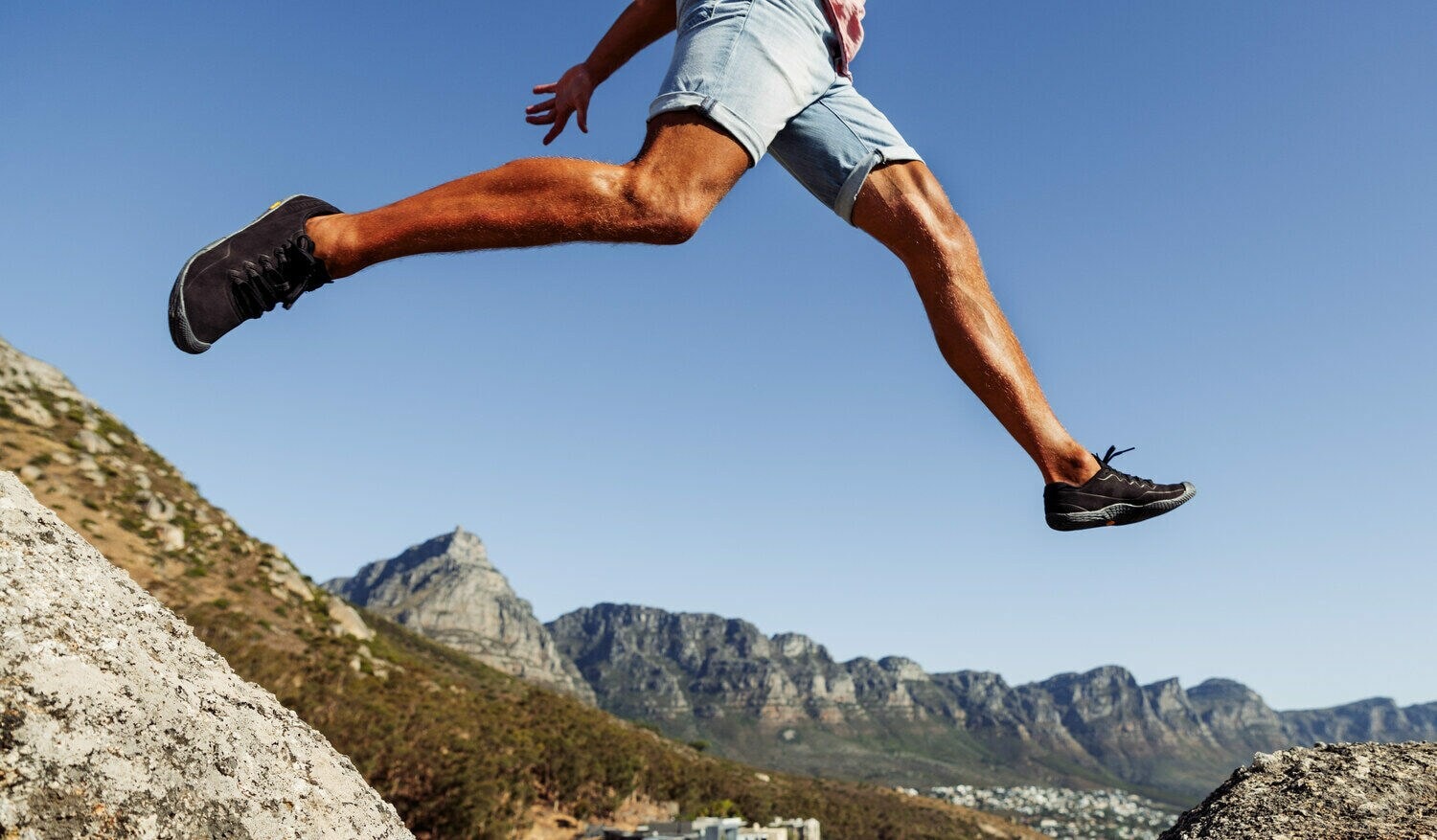 Ein junger Mann springt von Stein zu Stein Ein junger Mann springt von Stein zu Stein