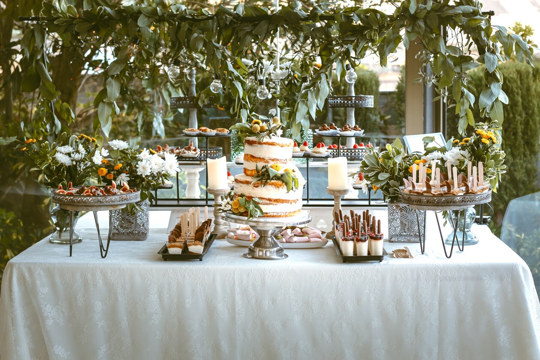 Eine Candy Bar mit einem Naked Cake in der Mitte und kleinen Dessertschälchen drumherum