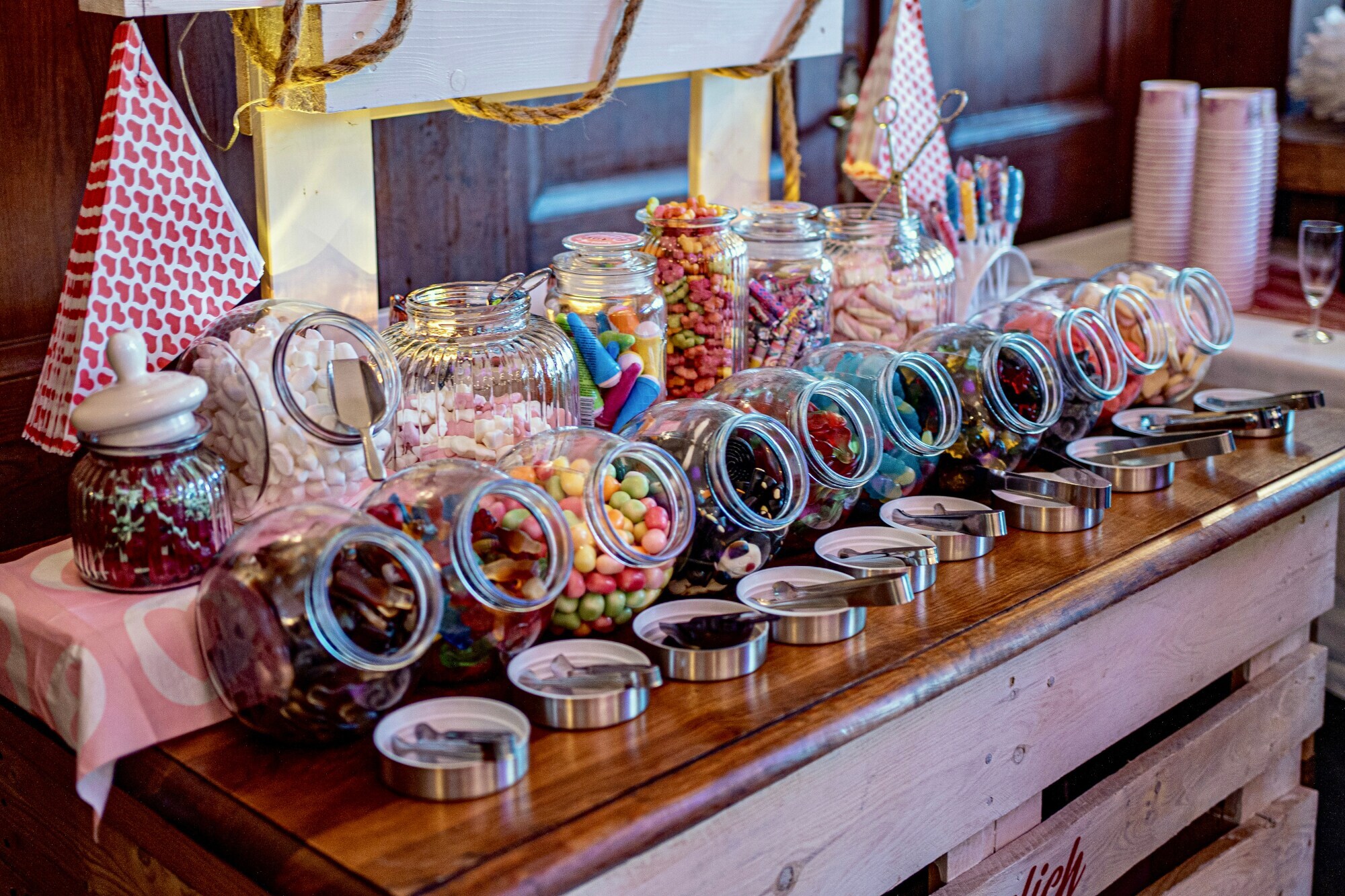 Ein Tisch mit vielen Gläsern, in denen Weingummi, Speckmäuse und mehr zu finden sind Ein Tisch mit vielen Gläsern, in denen Weingummi, Speckmäuse und mehr zu finden sind