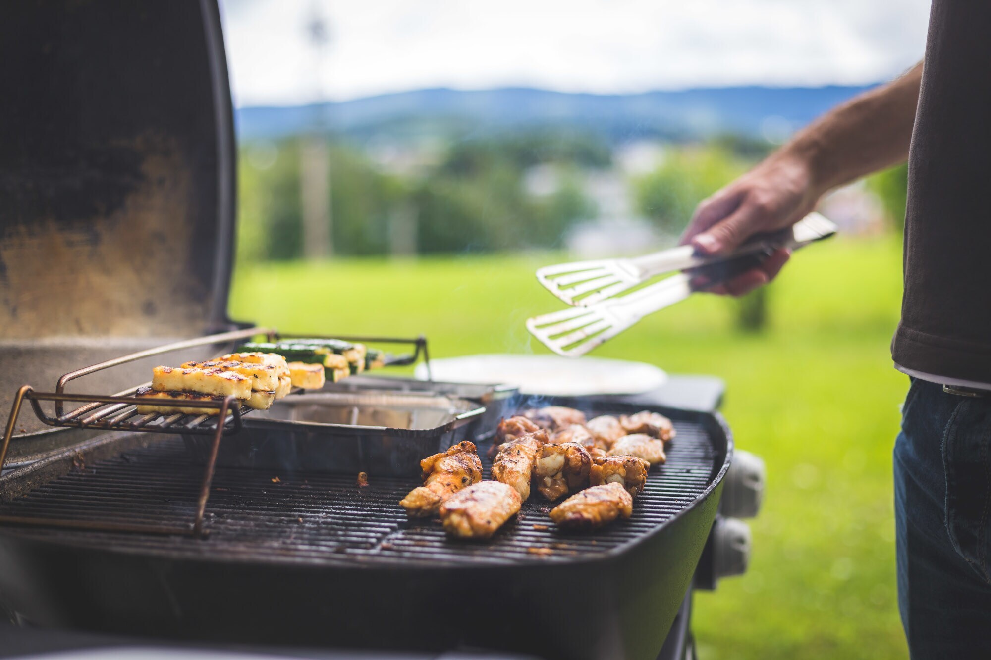 Hühnerflügel, Käse und Gemüse auf dem Gasgrill
