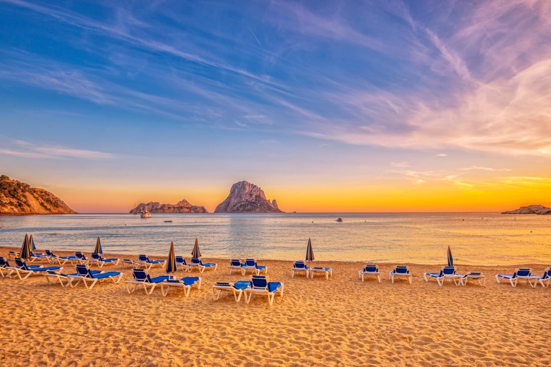 Ein Sandstrand mit Liegen bei Sonnenuntergang Ein Sandstrand mit Liegen bei Sonnenuntergang