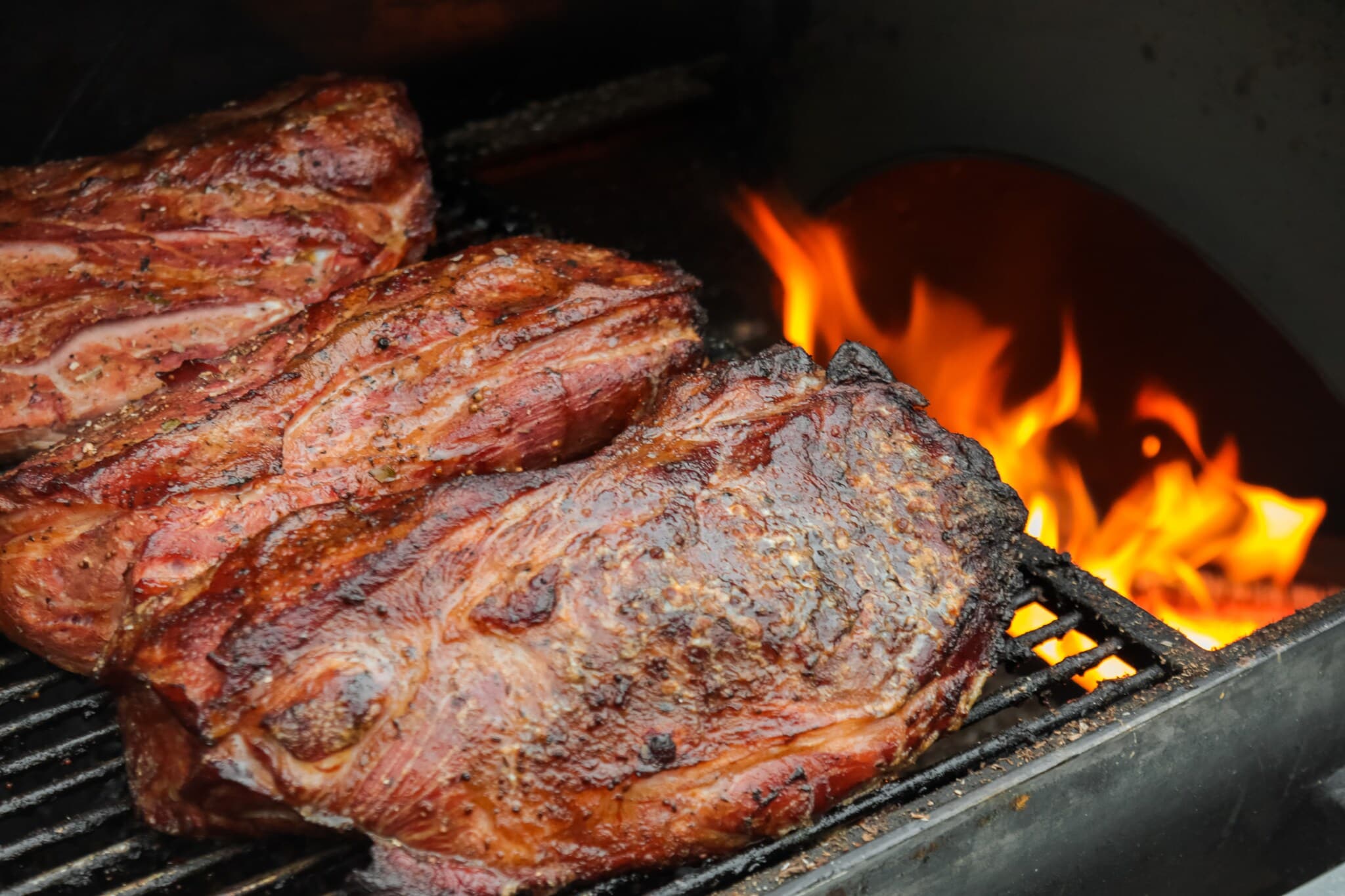 Fleisch wird indirekt neben einer Flamme im Grill gegrillt Fleisch wird indirekt neben einer Flamme im Grill gegrillt