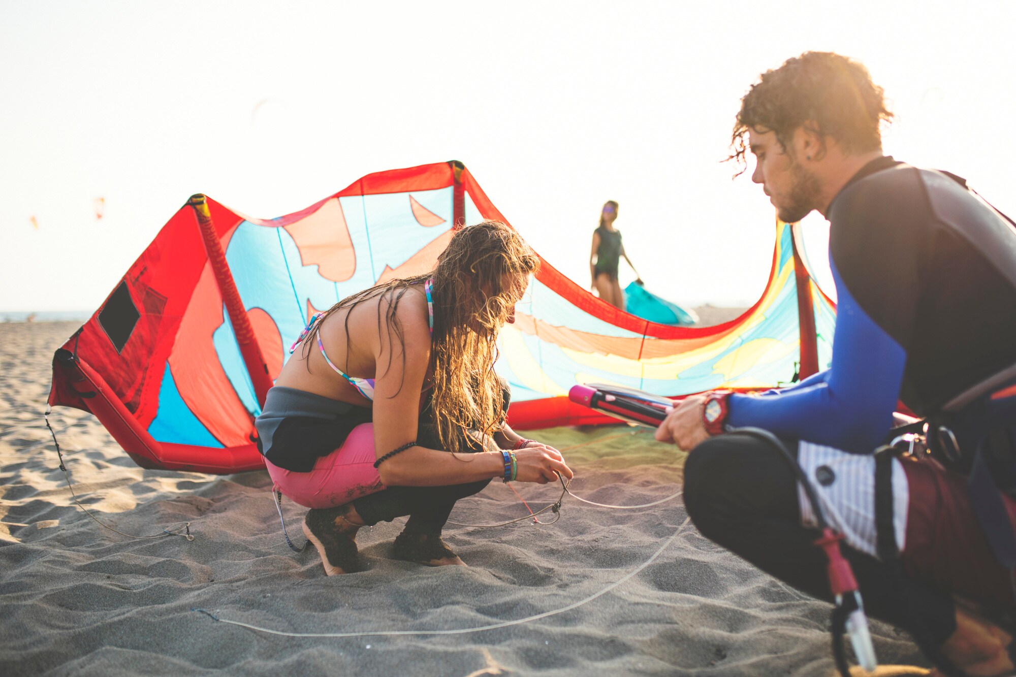 Kitesurferin prüft ihre Ausrüstung am Strand