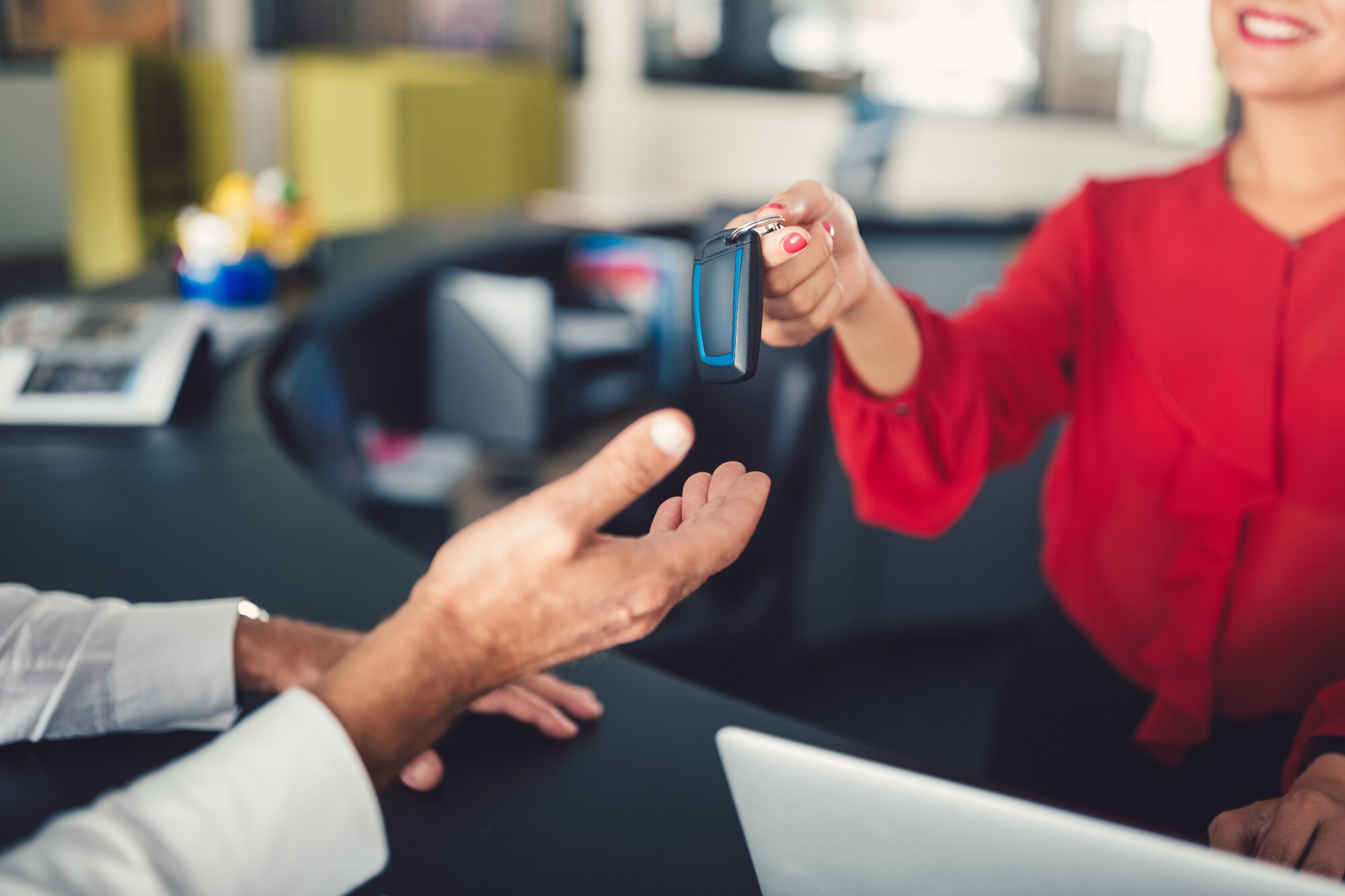 Übergabe eines Autoschlüssels am Schalter