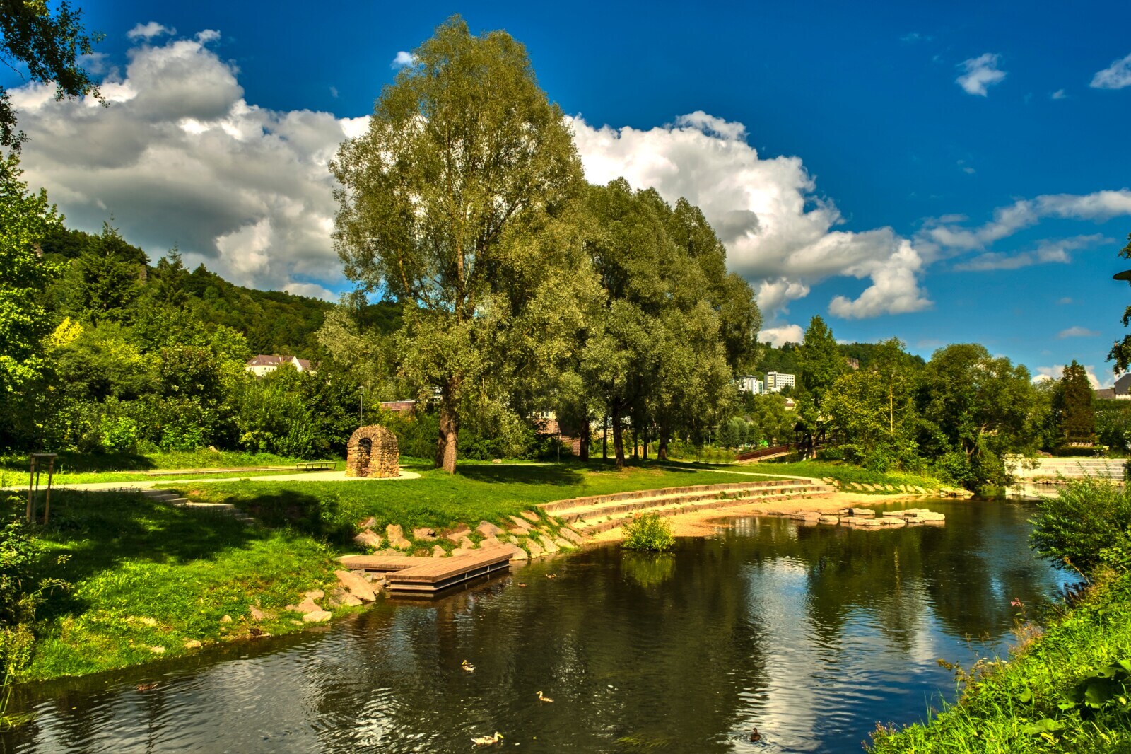 Ein Fluß mit einer Parkanlage im Sommer