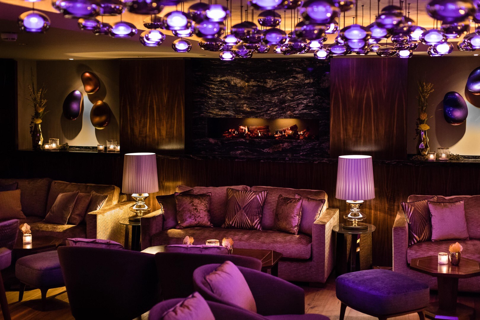 Gemütlich eingerichteter Lounge-Bereich mit Sofas und lilafarbener Beleuchtung