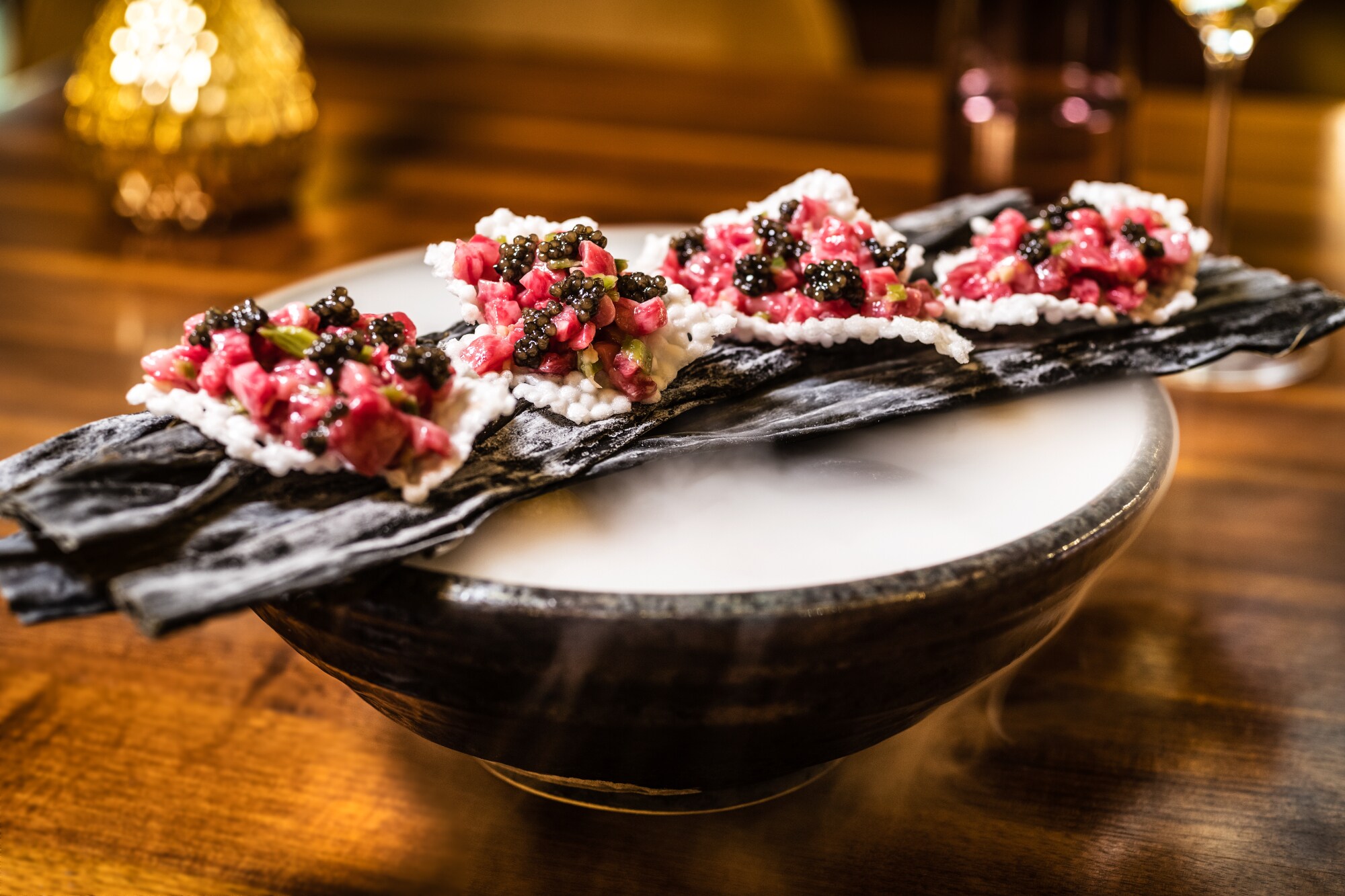 Ein aufwendig zubereitetes Tatar auf einer dampfenden Schale