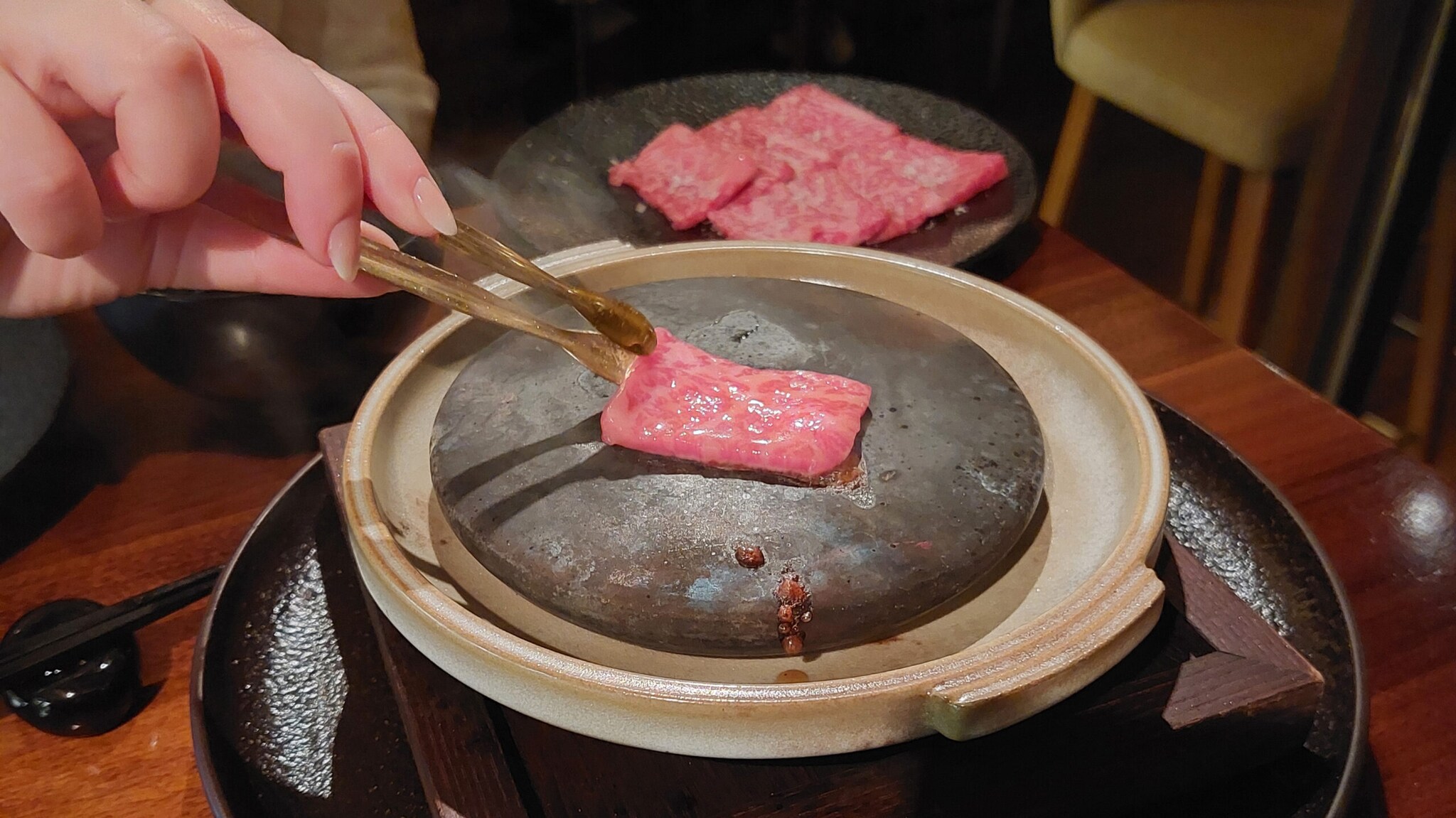Ein dünnes Stück Wagyu wird auf einem heißen Stein zubereitet