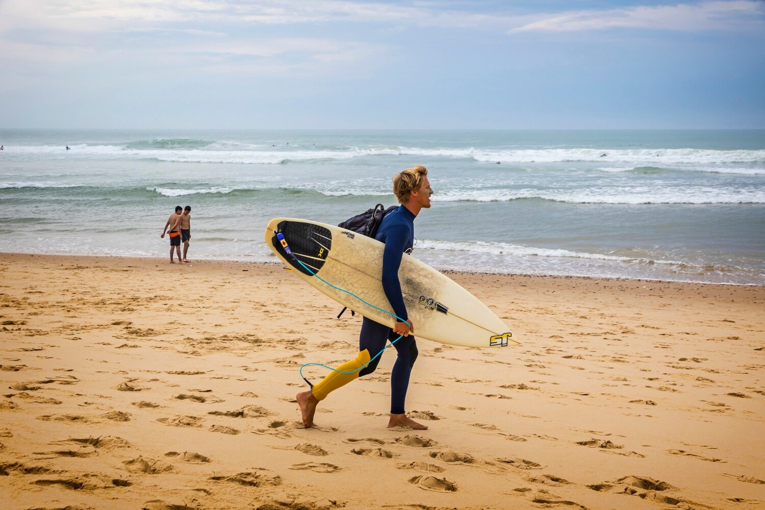 Ein Surfer mit Surfbrett an einem Strand Ein Surfer mit Surfbrett an einem Strand
