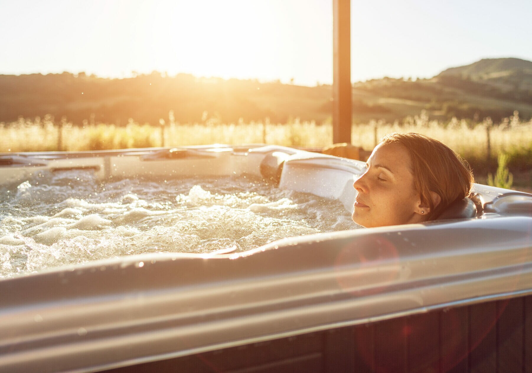 Frau im Whirlpool bei Sonnenuntergang