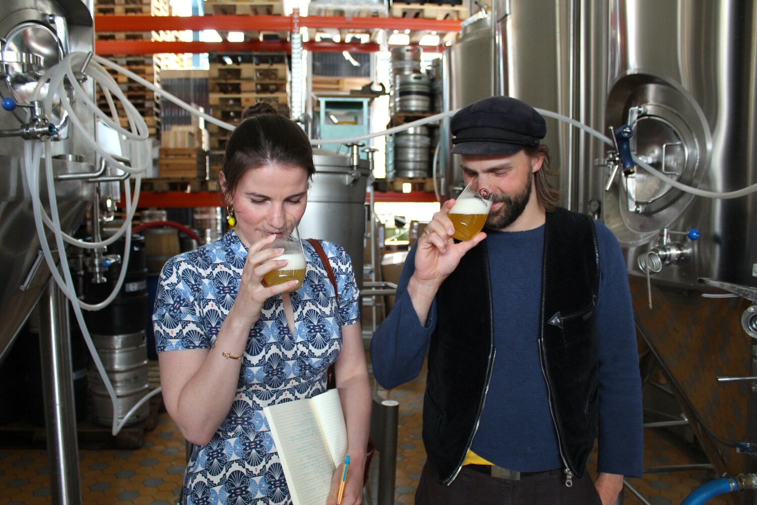 Zwei Personen riechen an gefüllten Biergläsern in einer Brauerei Zwei Personen riechen an gefüllten Biergläsern in einer Brauerei