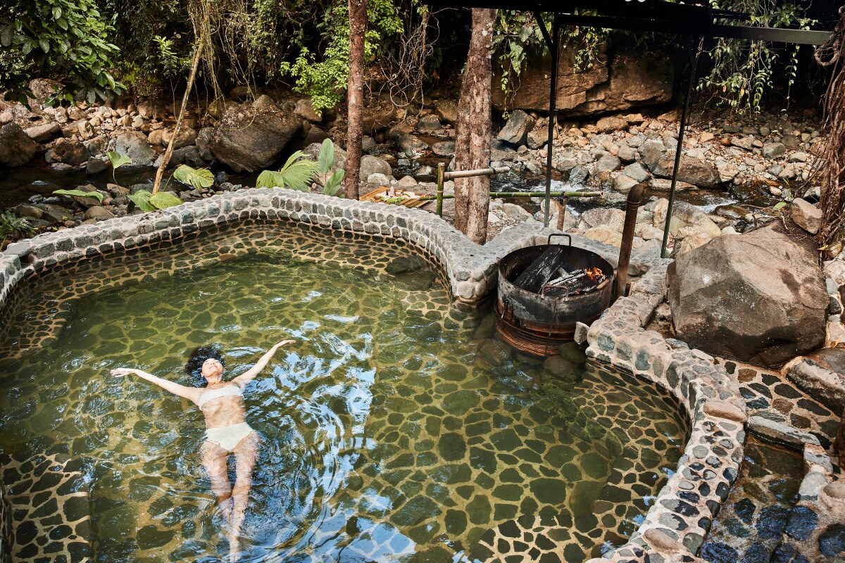 Eine Frau im weißen Bikini lässt sich in einem Teich treiben Eine Frau im weißen Bikini lässt sich in einem Teich treiben