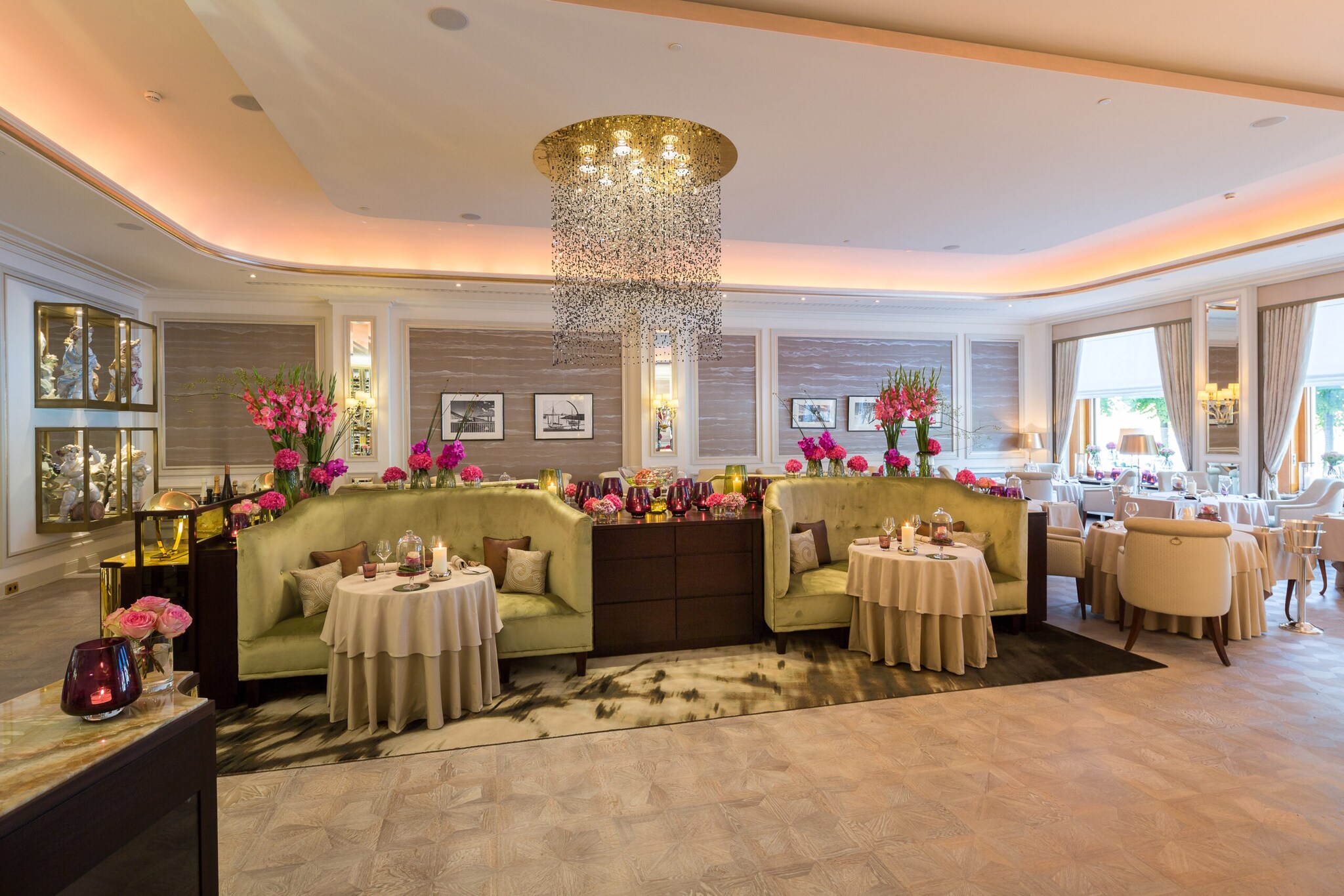 Luxuriöses Interieur des Drei-Sterne-Restaurants Haerlin mit kleinen gedeckten Tischen vor gepolsterten Sofas.