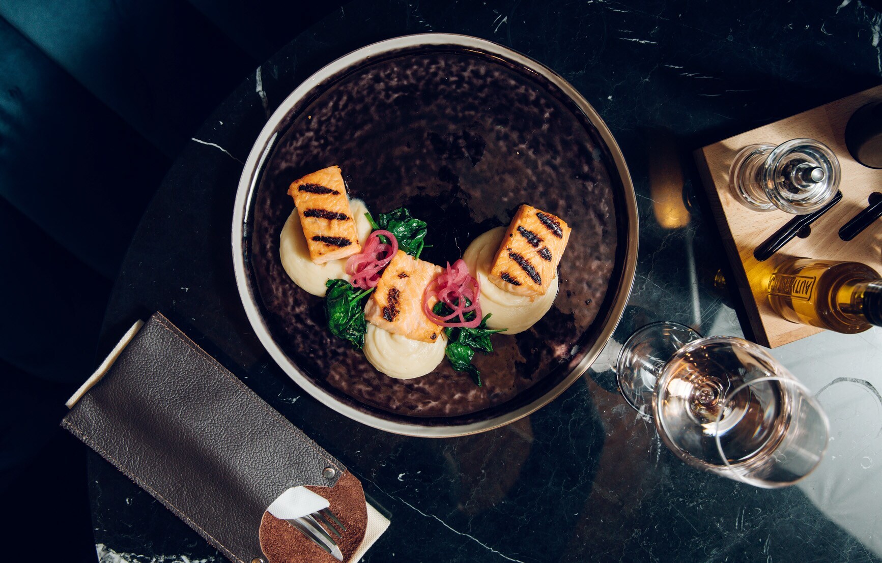 Exquisit angerichtete Speisen auf einem dunklen Teller, von oben fotografiert Exquisit angerichtete Speisen auf einem dunklen Teller, von oben fotografiert