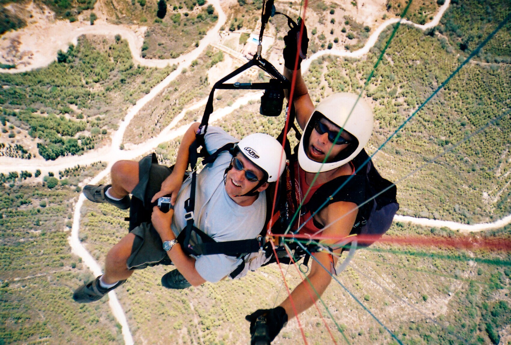 Zwei fröhliche Männer im Fallschirm genießen die Aussicht