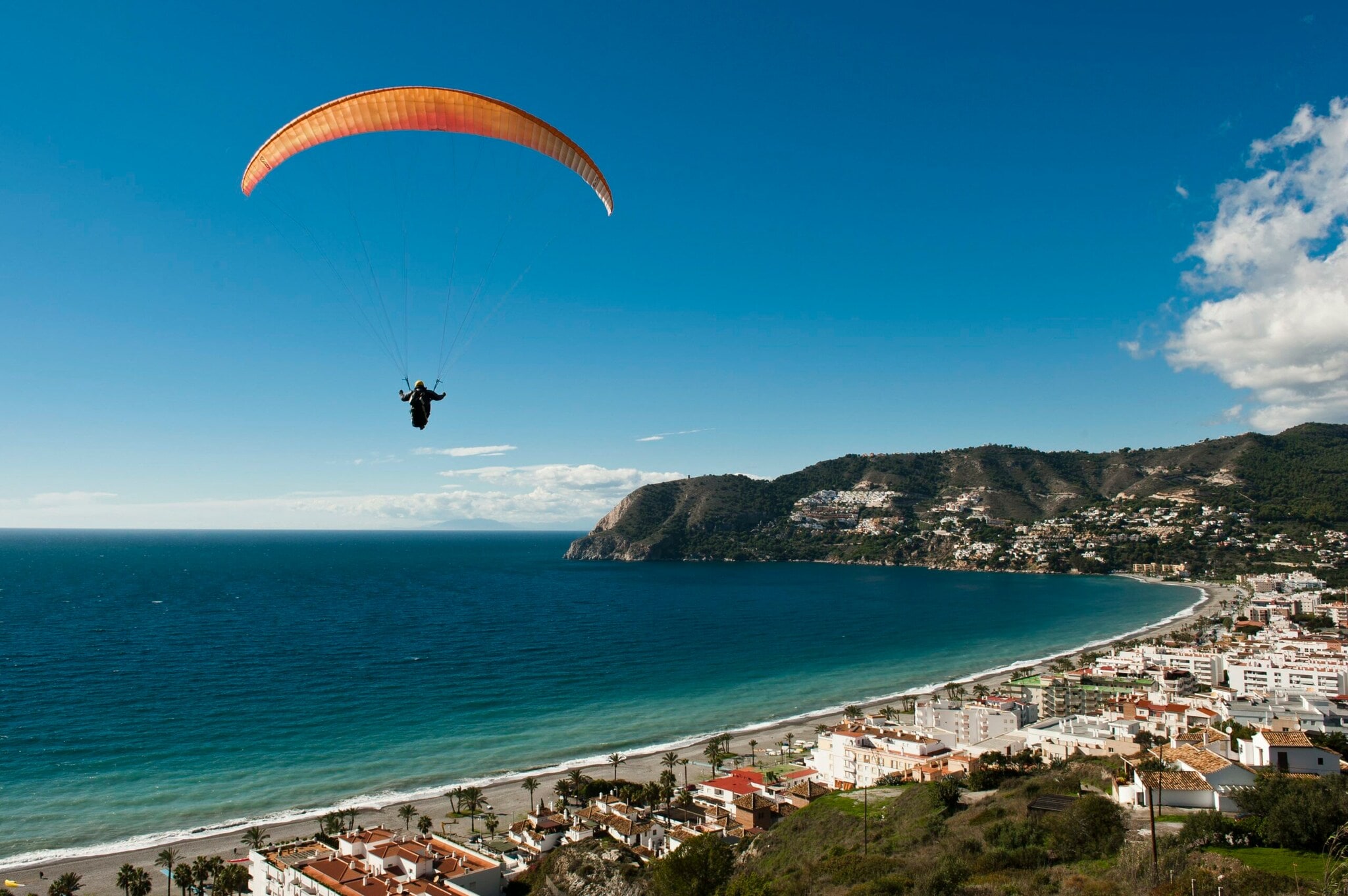Ein Paraglider schwebt über einer Küstenstadt Ein Paraglider schwebt über einer Küstenstadt