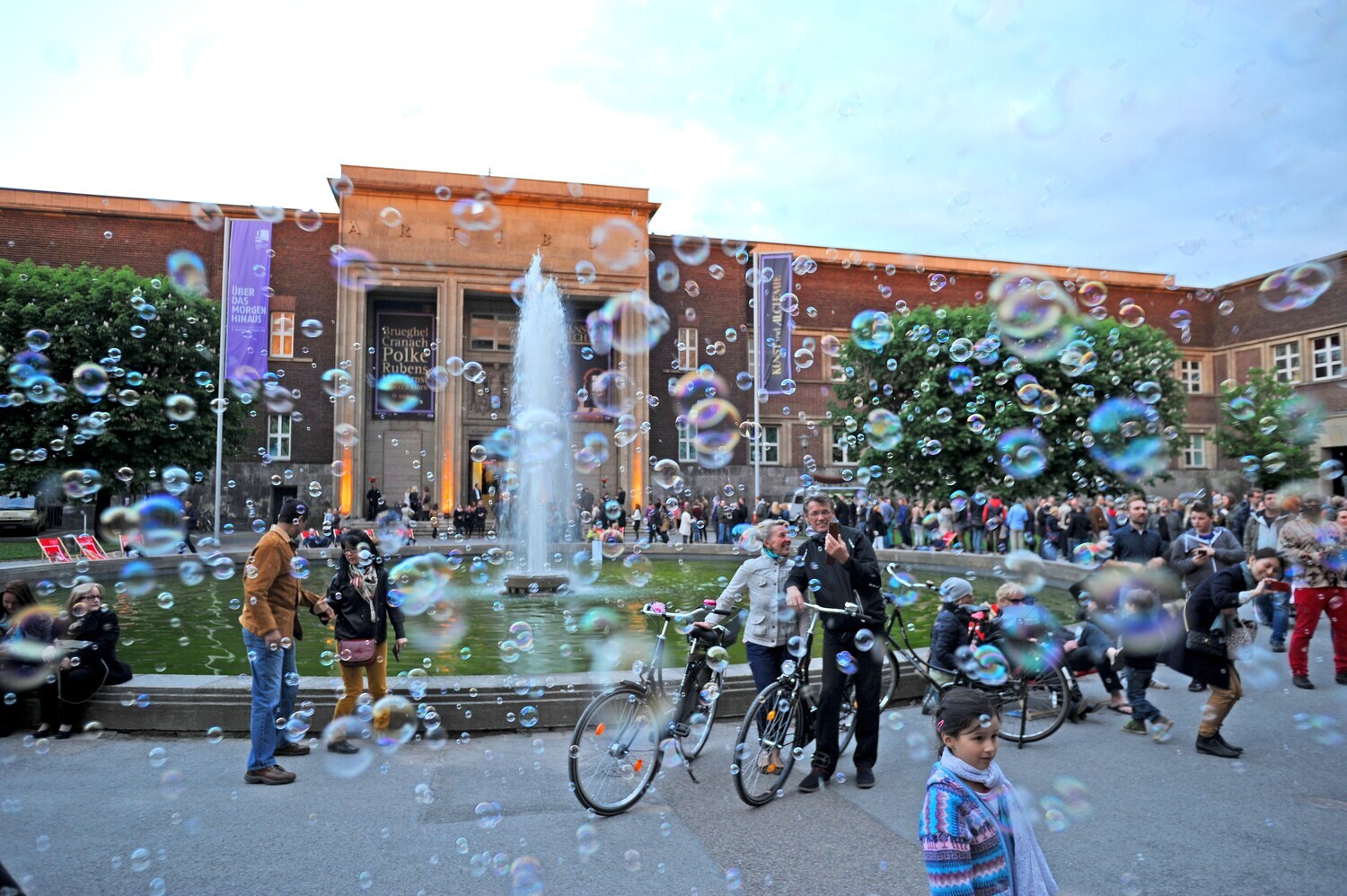 Menschen vor einem Museum mit vielen Seifenblasen
