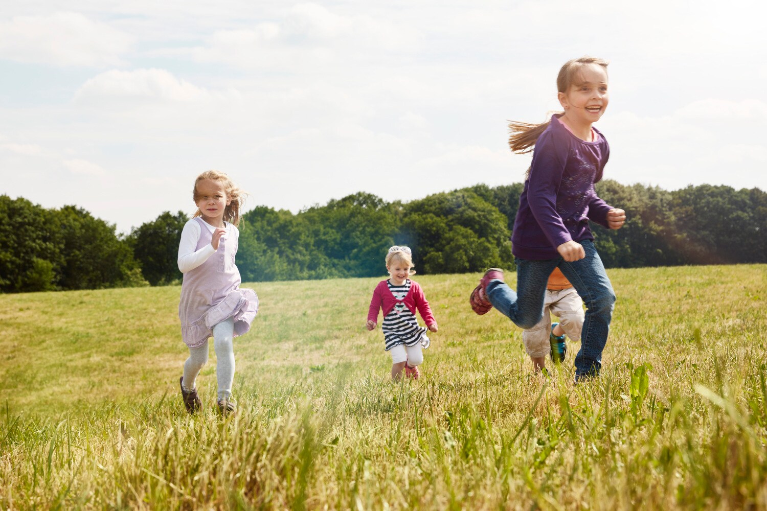 Vier Kinder spielen auf einer Wiese