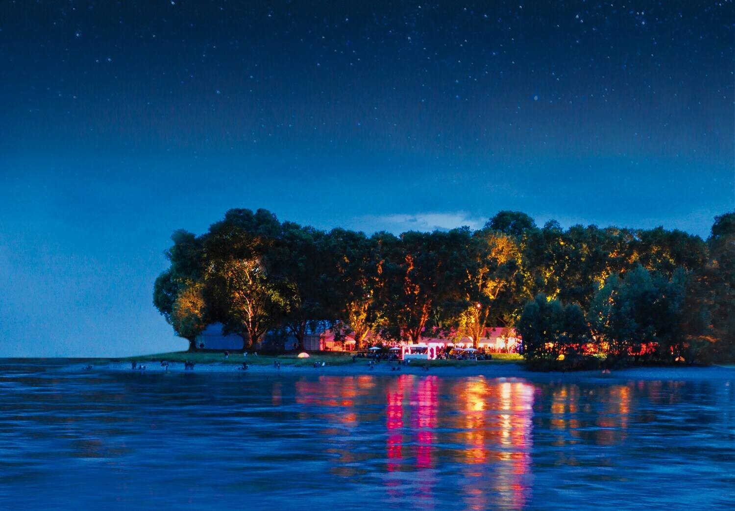 Blick über einen Fluß auf eine beleuchtete Insel