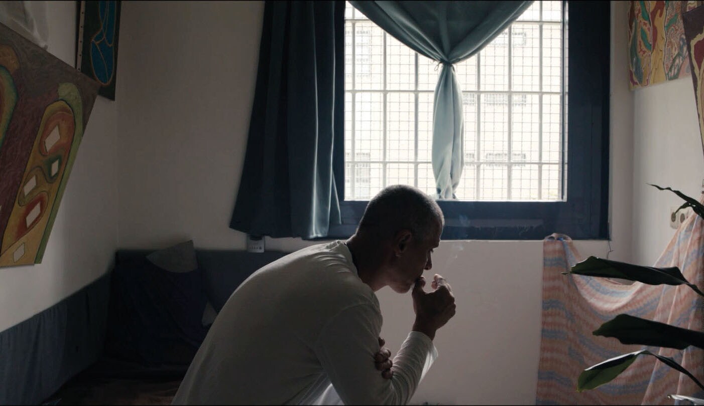 Filmstill eines nachdenklichen Mannes in einem kleinen Raum