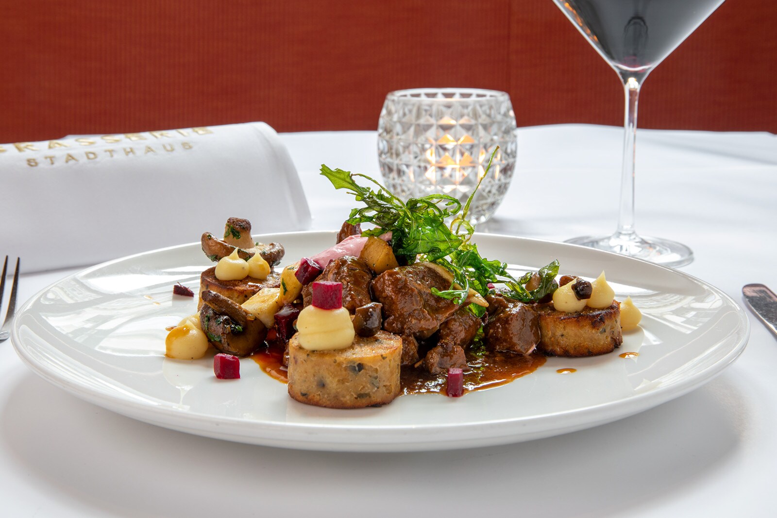 Wildragout auf einem weißen Teller angerichtet