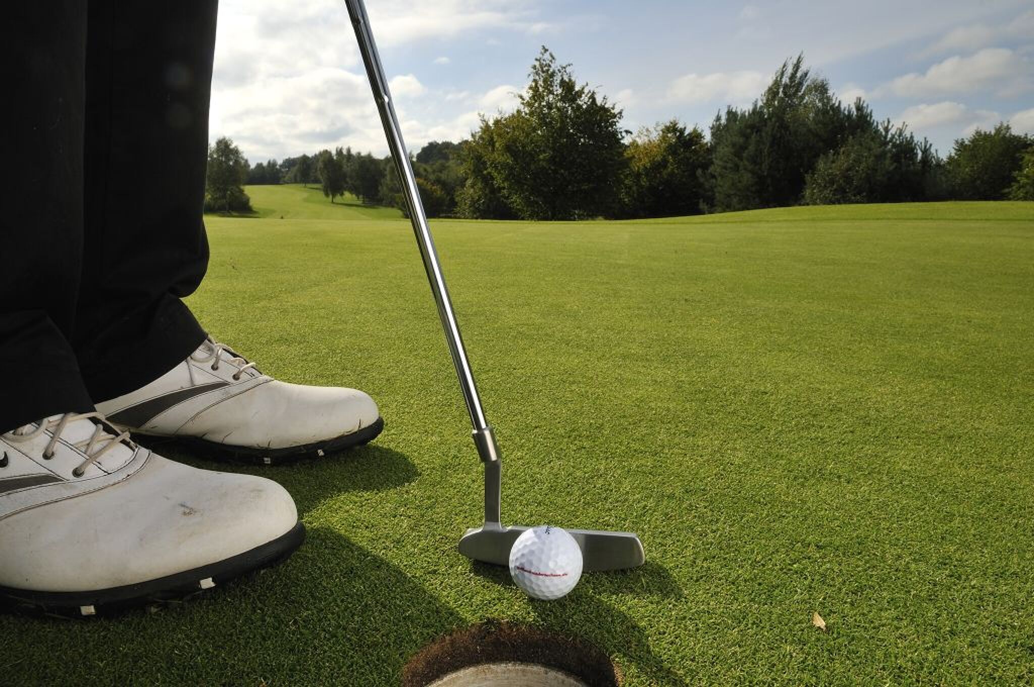 Nachaufnahme eines Goldballs, kurz bevor er ins Loch fällt