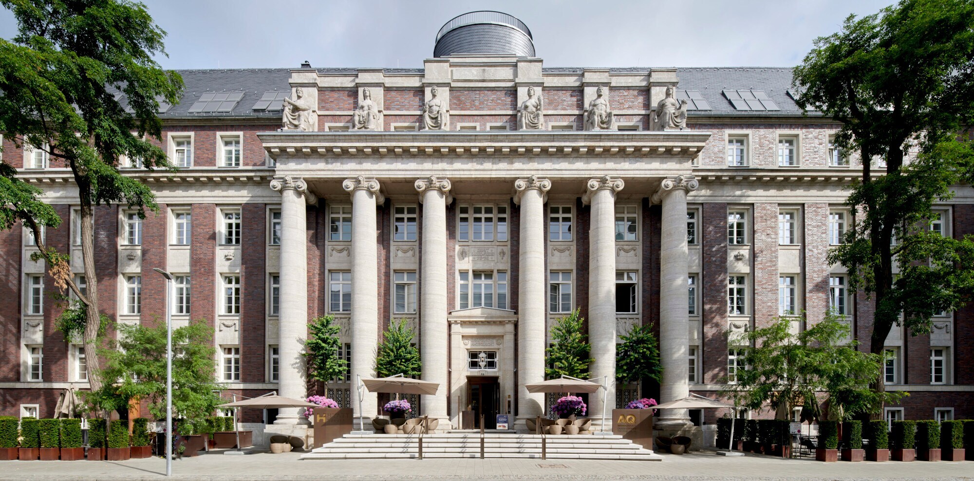 Frontansicht eines imposanten Gebäudes im Neobarocken Stil mit Säulen vor dem Eingang