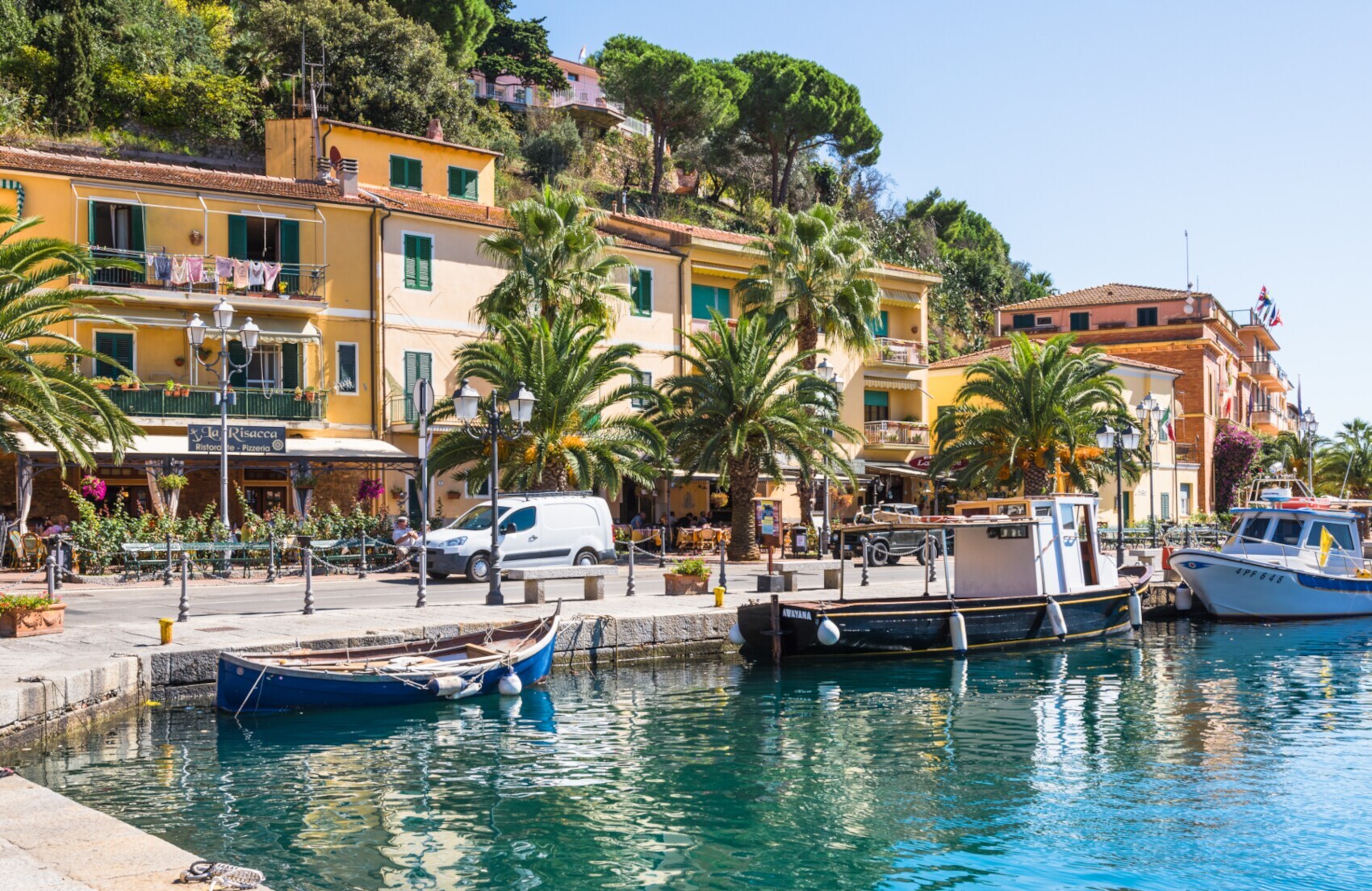 Fischerboote, die im Hafen von Porto Azzuro vor der Promenade liegen