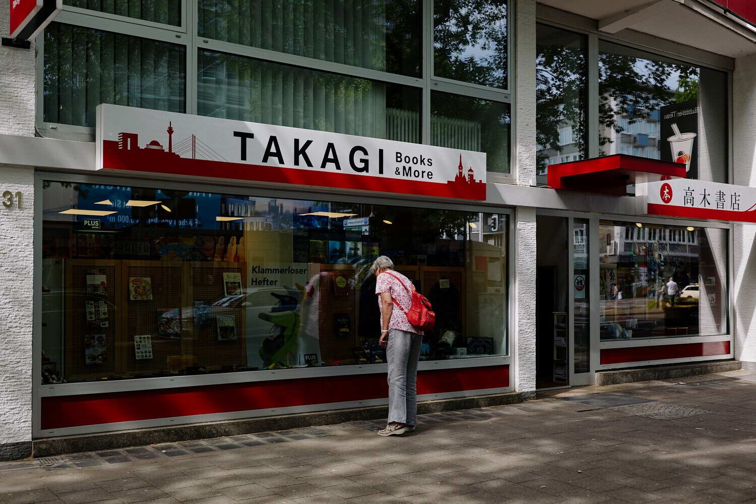 Eine Frau steht vor dem Schaufenster einer japanischen Buchhandlung Eine Frau steht vor dem Schaufenster einer japanischen Buchhandlung