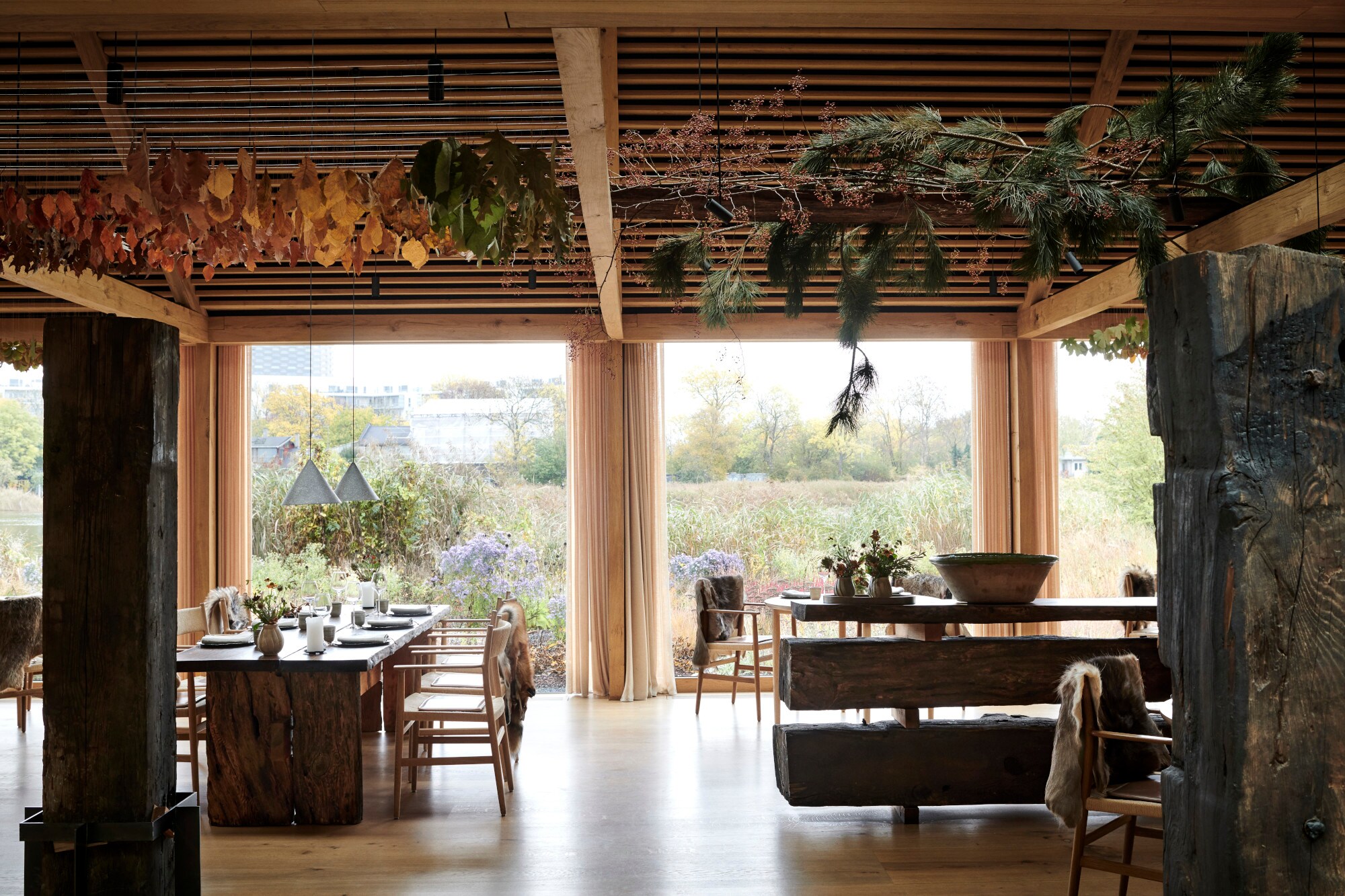 Innenraum eines Restaurants mit Blick nach draußen auf eine Wiese voller Wildblumen Innenraum eines Restaurants mit Blick nach draußen auf eine Wiese voller Wildblumen