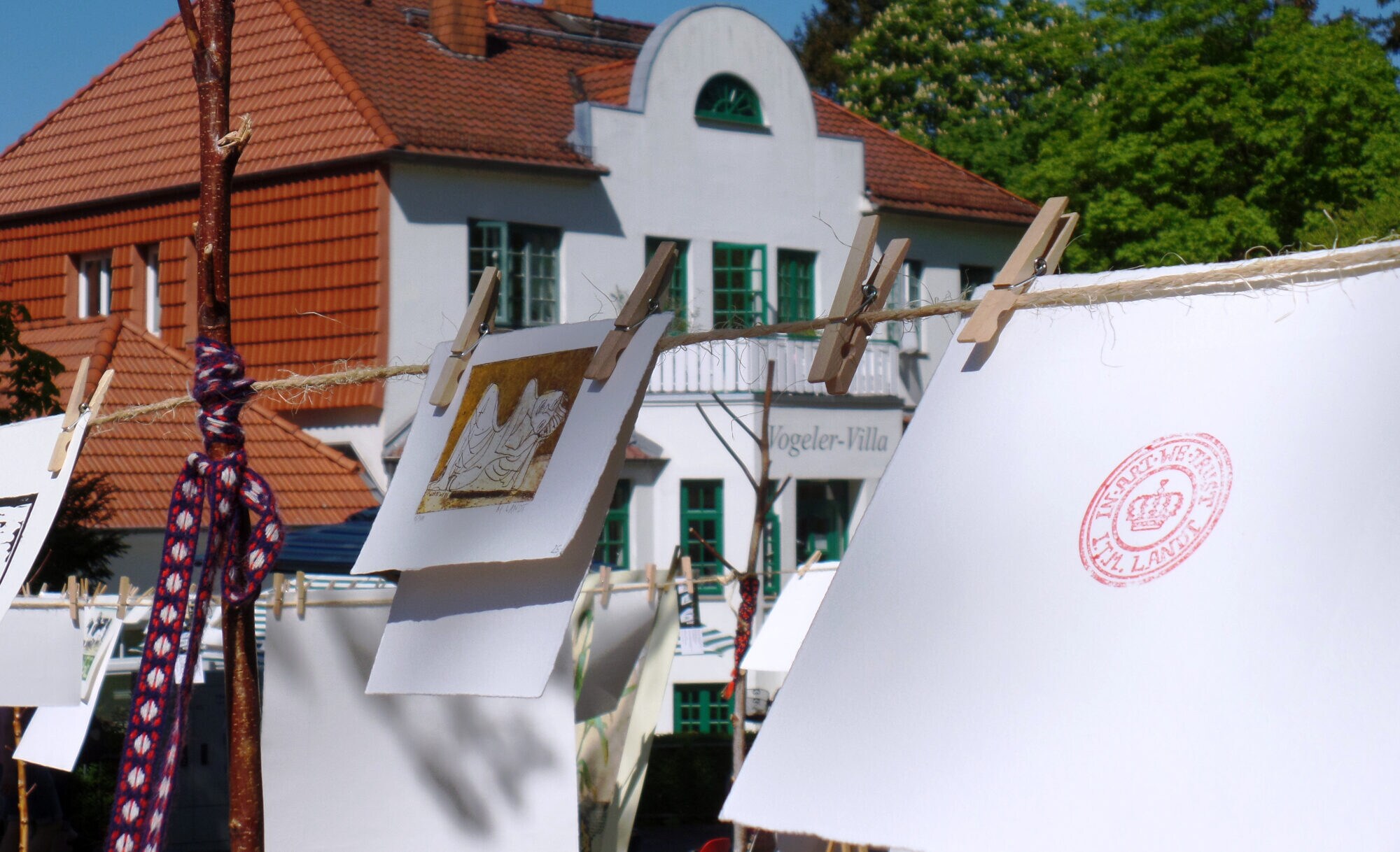 Bilder hängen an einer Wäscheleine mit Klammern unter freiem Himmel