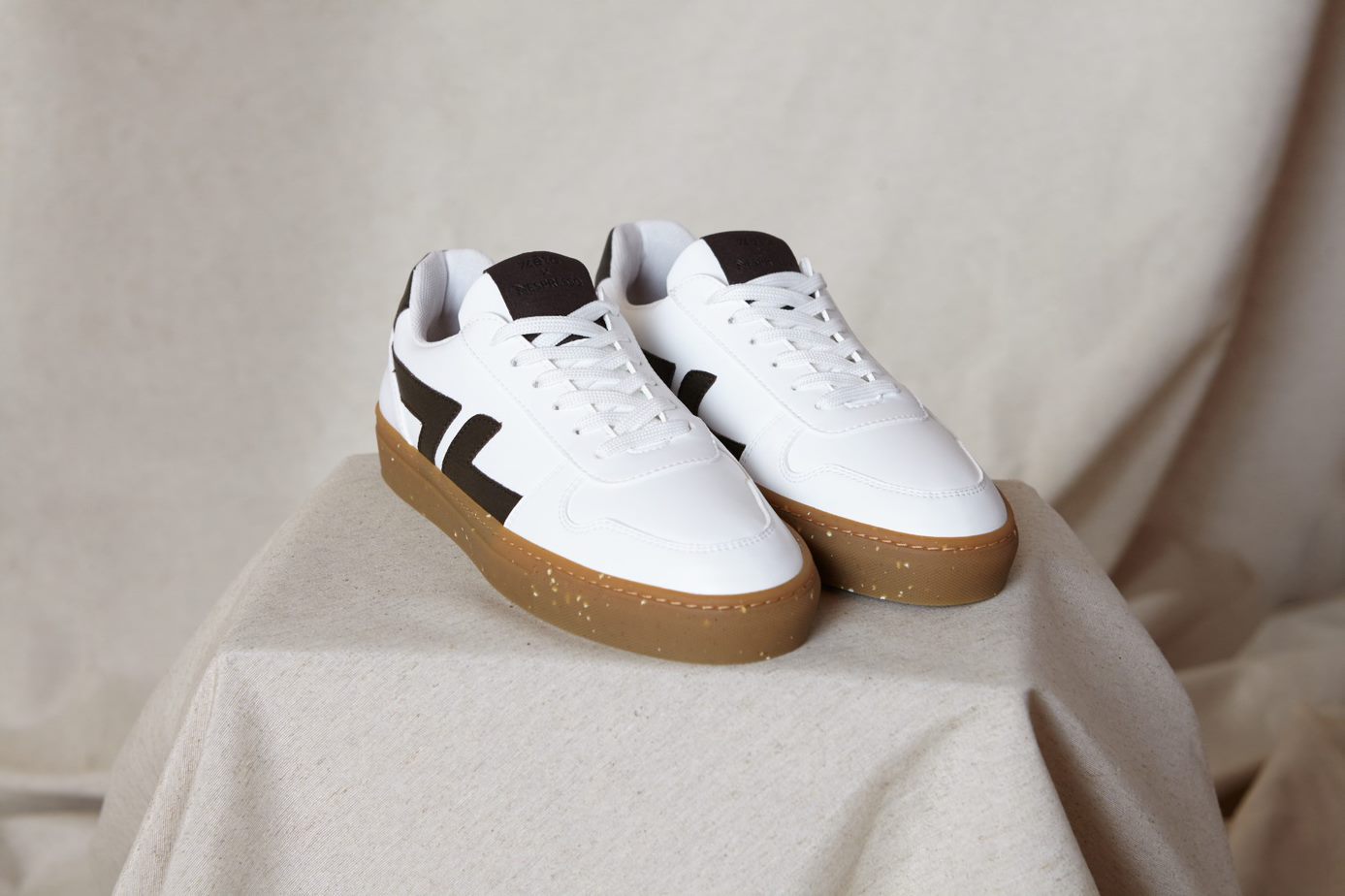 Weiße Sneaker mit brauner Sohle und dunkelbraunen Applikationen