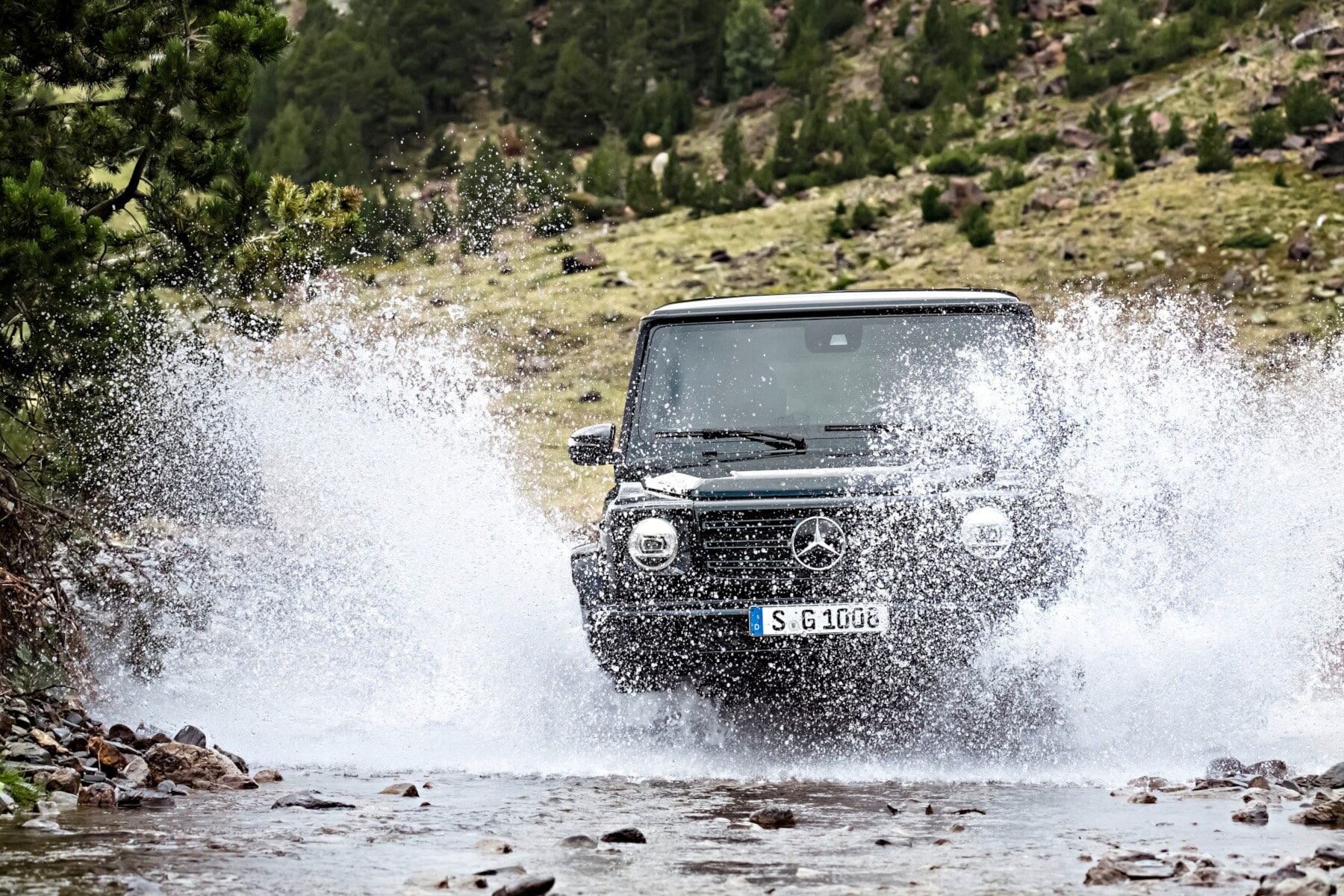 Geländefahrzeug im hoch spritzenden Wasser Geländefahrzeug im hoch spritzenden Wasser
