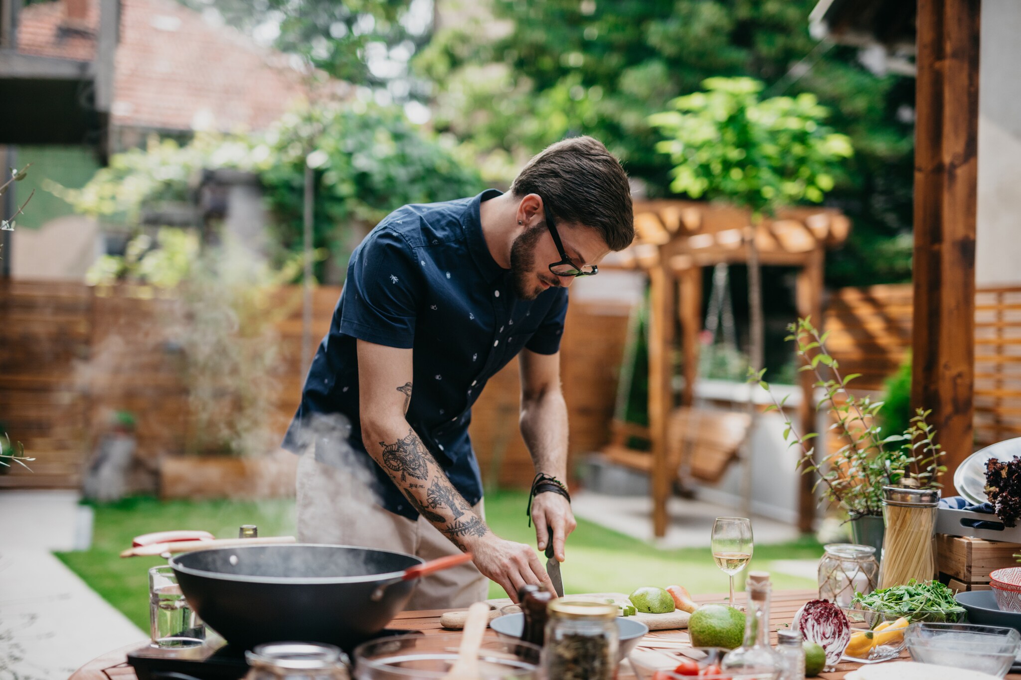Ein Mann bereitet in einer Outdoorküche ein Gericht zu