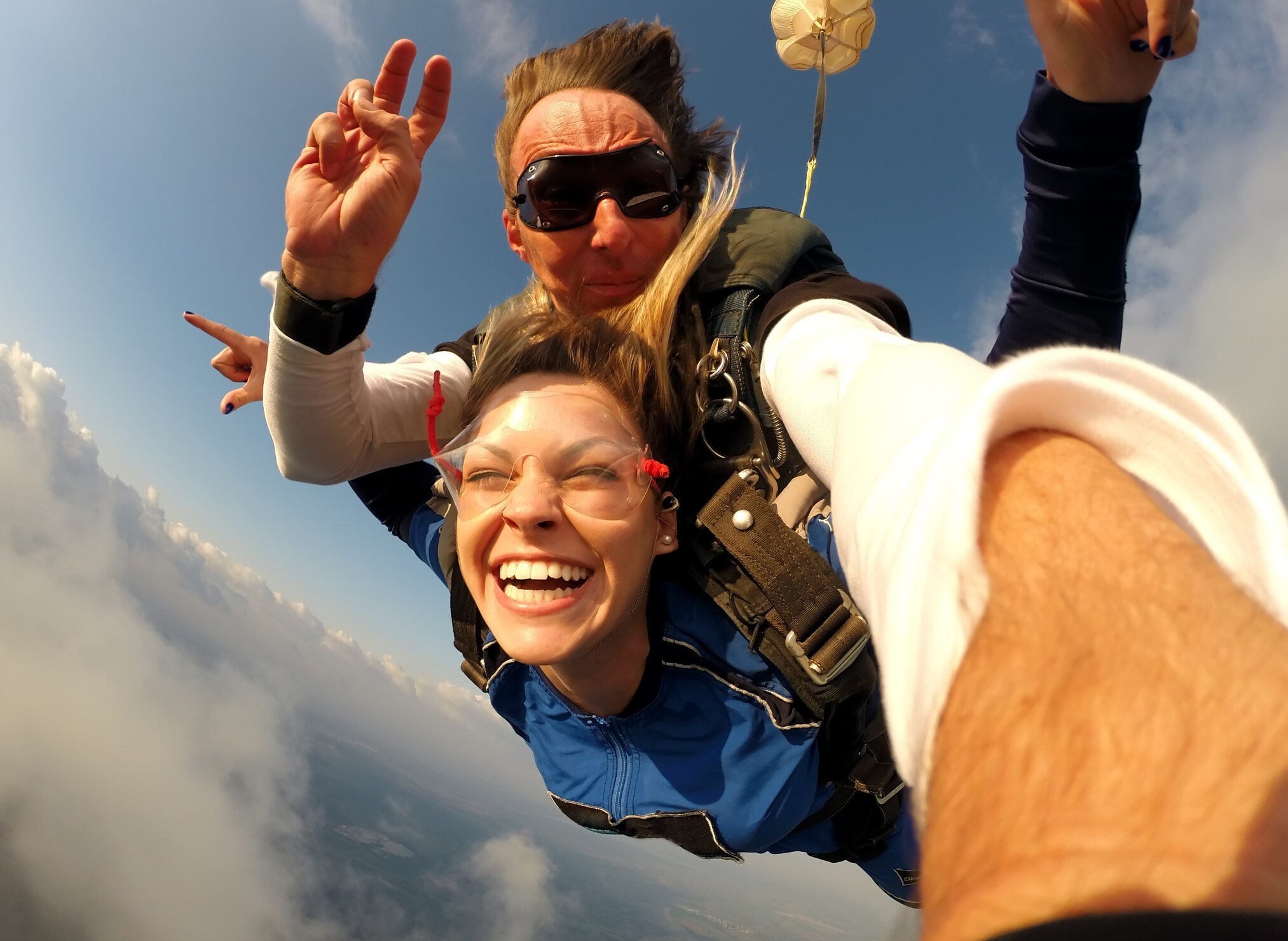 Ein Mann und eine fröhliche Frau beim Tandem-Fallschirmspringen. Ein Mann und eine fröhliche Frau beim Tandem-Fallschirmspringen.